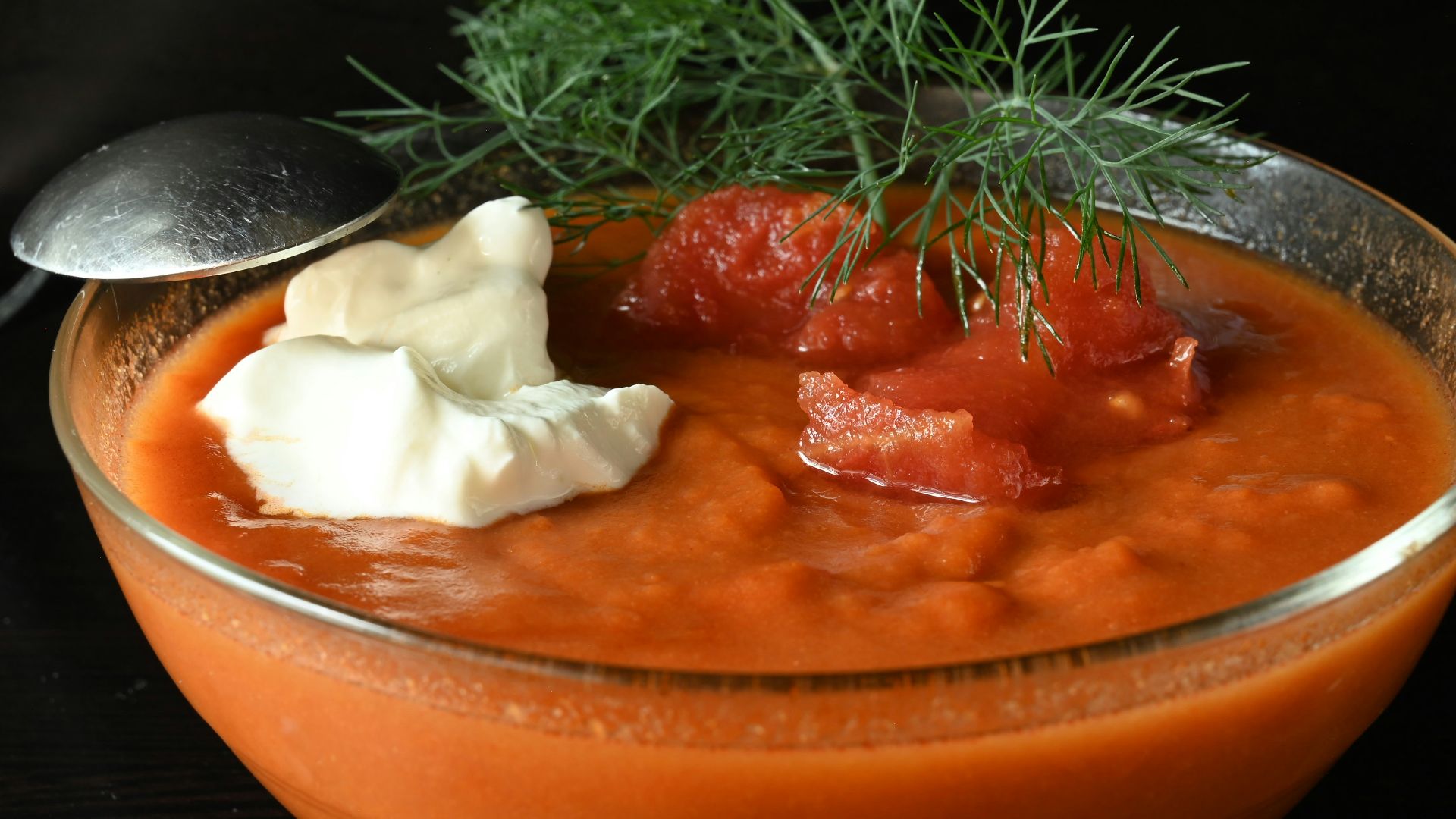 A bowl of tomato soup with a spoon