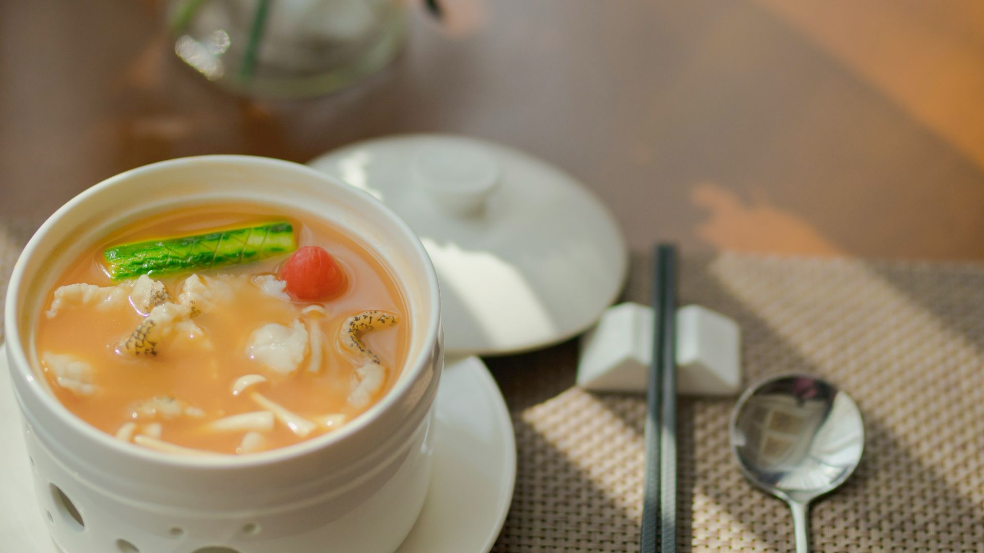 white ceramic bowl with soup and stainless steel spoon on table