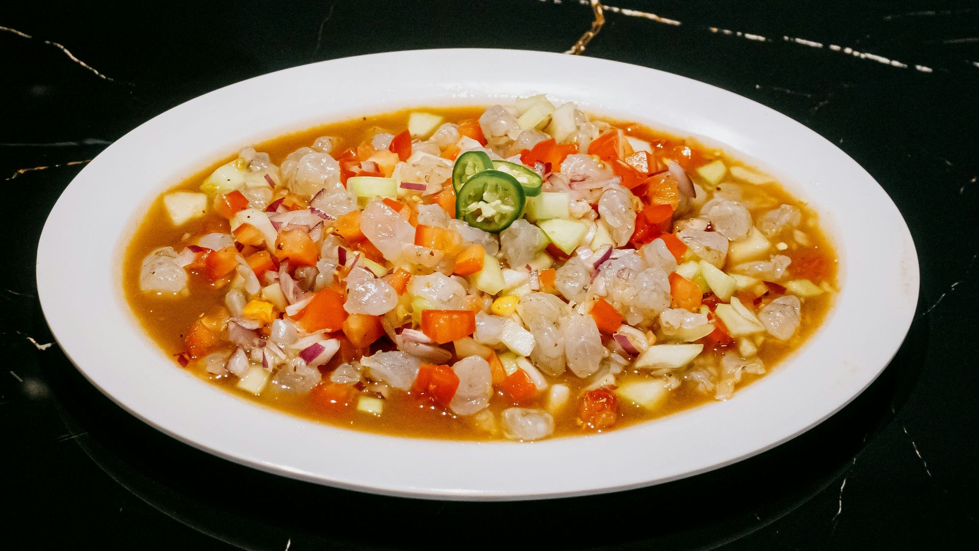 A white plate topped with a stew of vegetables