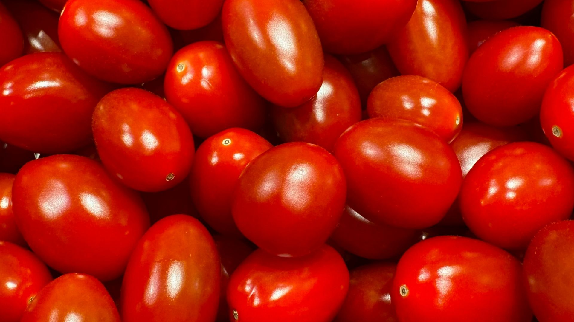 a pile of red tomatoes sitting on top of each other