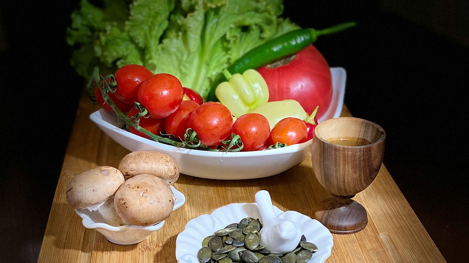 a wooden cutting board topped with a bowl of vegetables
