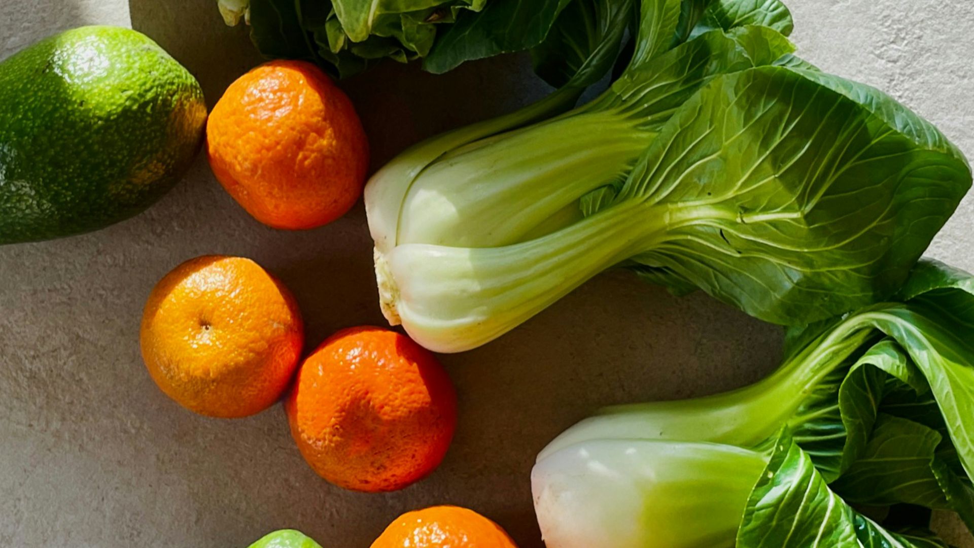 a table topped with lettuce, carrots and other vegetables