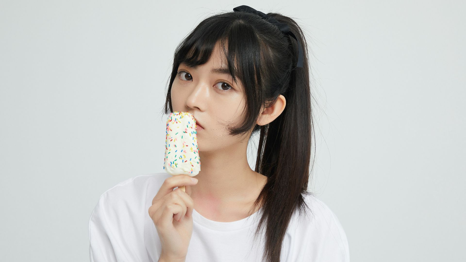 a woman eating a donut with sprinkles on it