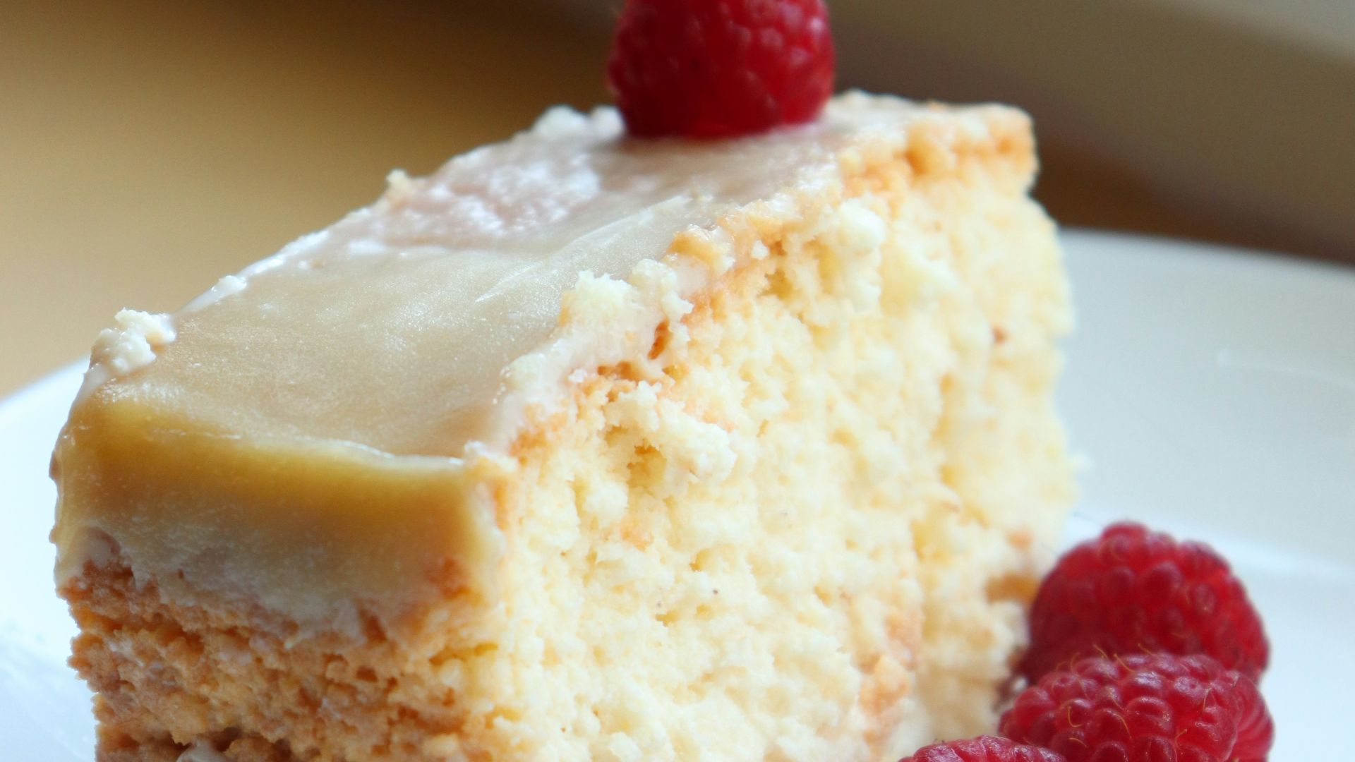 a piece of cake on a plate with raspberries