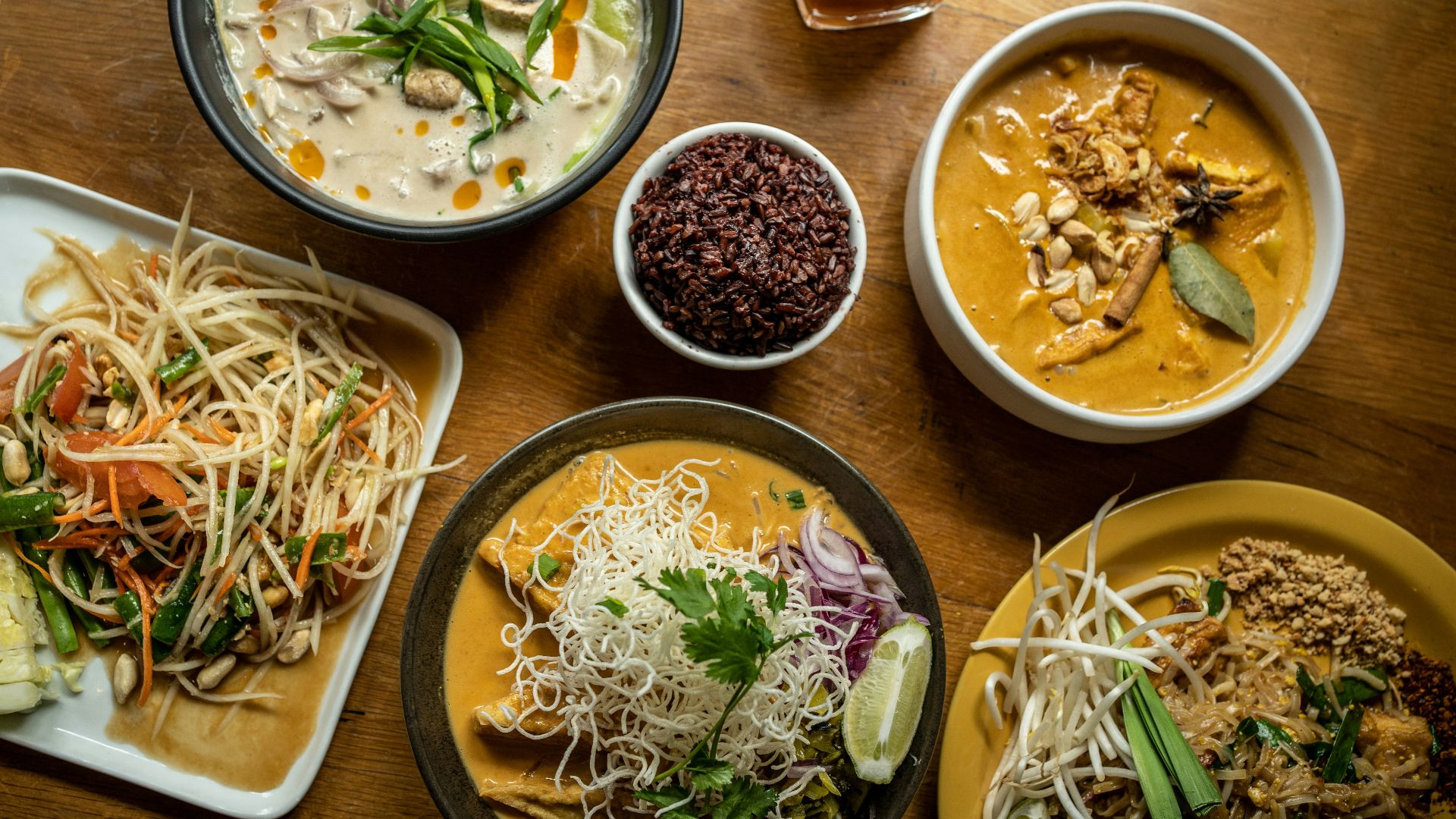 a wooden table topped with plates of food
