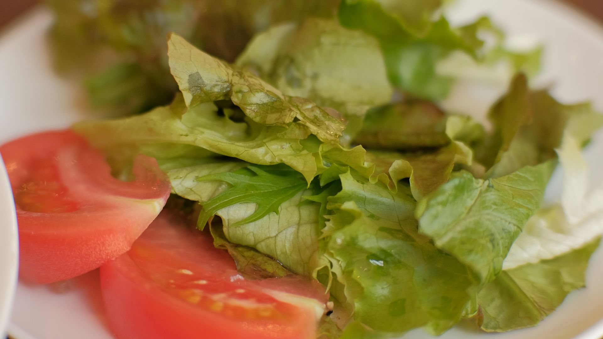 a white plate topped with lettuce and tomatoes