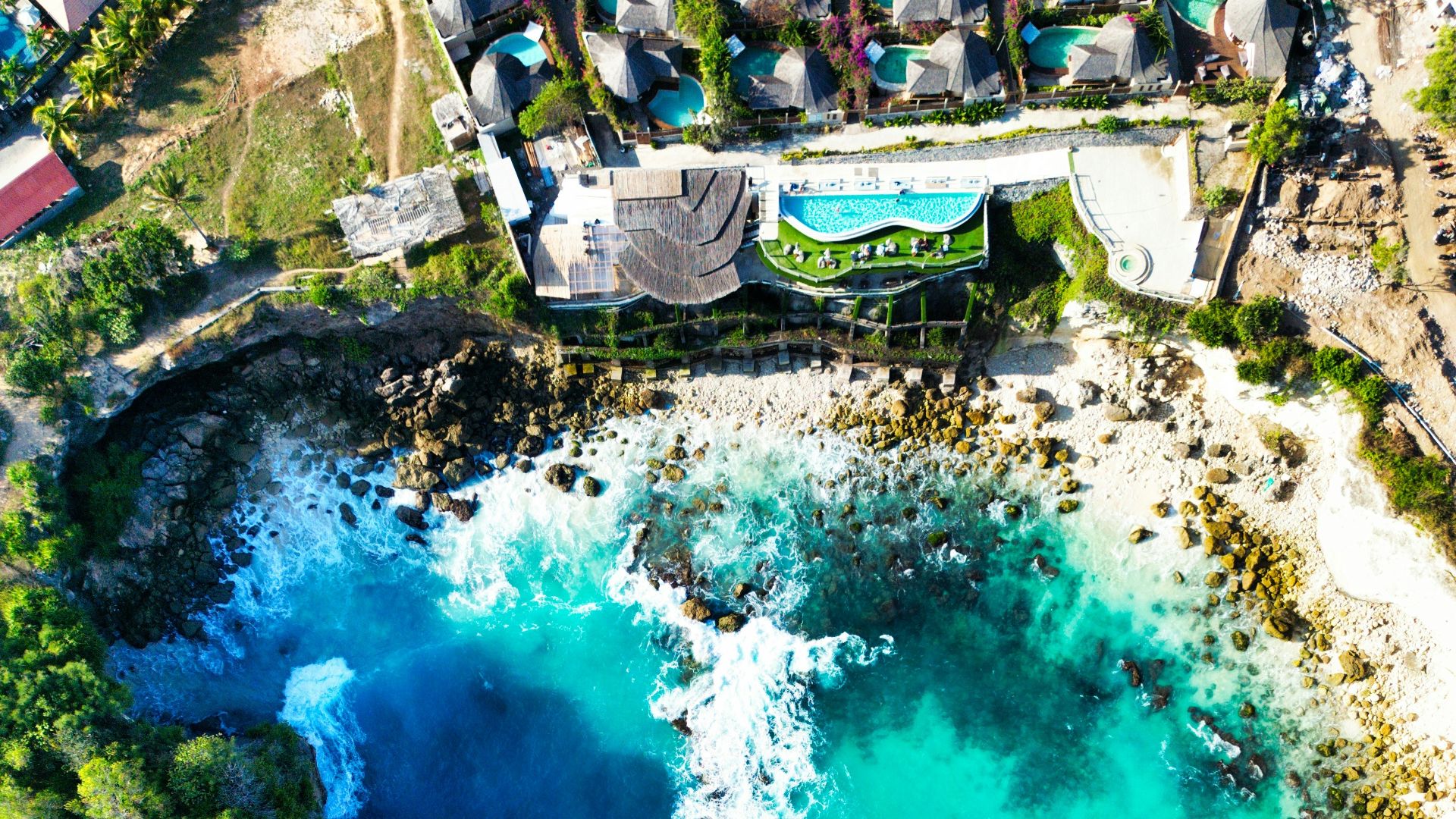 An aerial view of a resort and a body of water