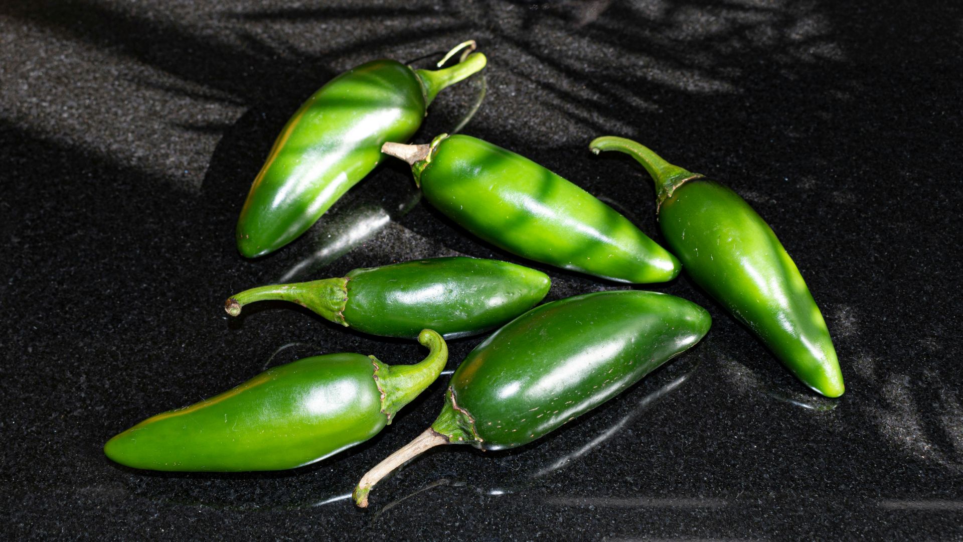 a group of green peppers sitting on top of a counter