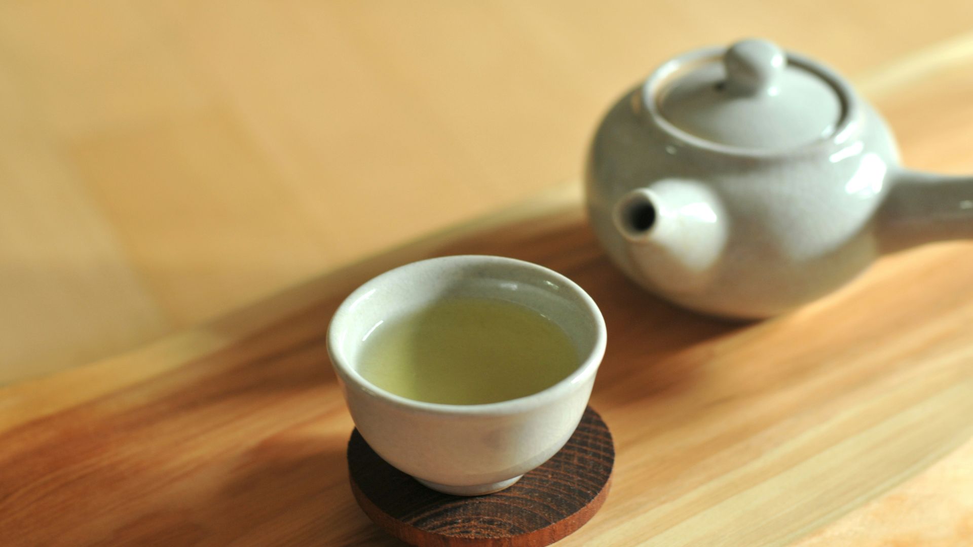 white ceramic teacup on brown wooden table