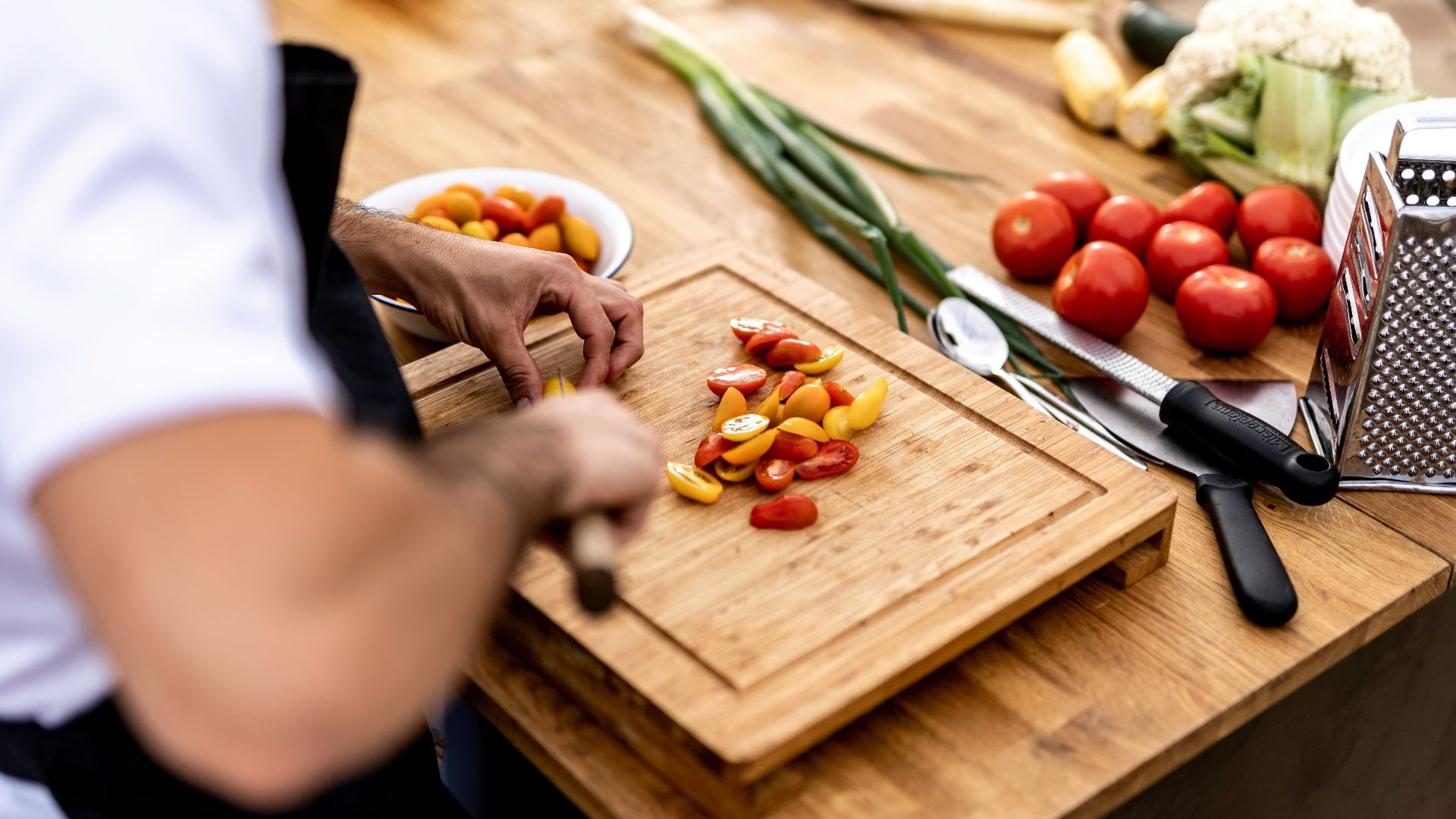 a person cutting up vegetables on a cutting board