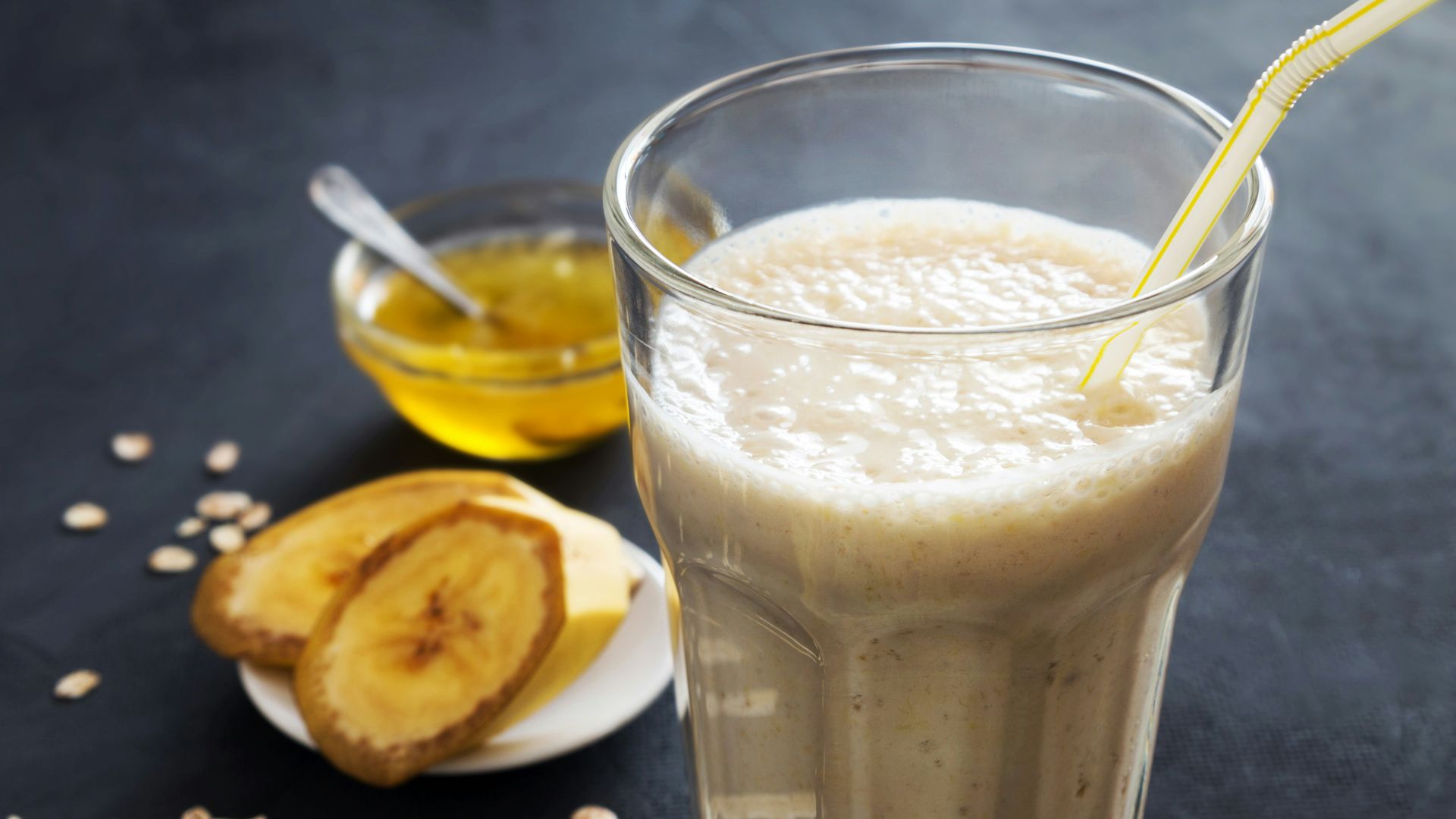 A glass of milk with a spoon next to it