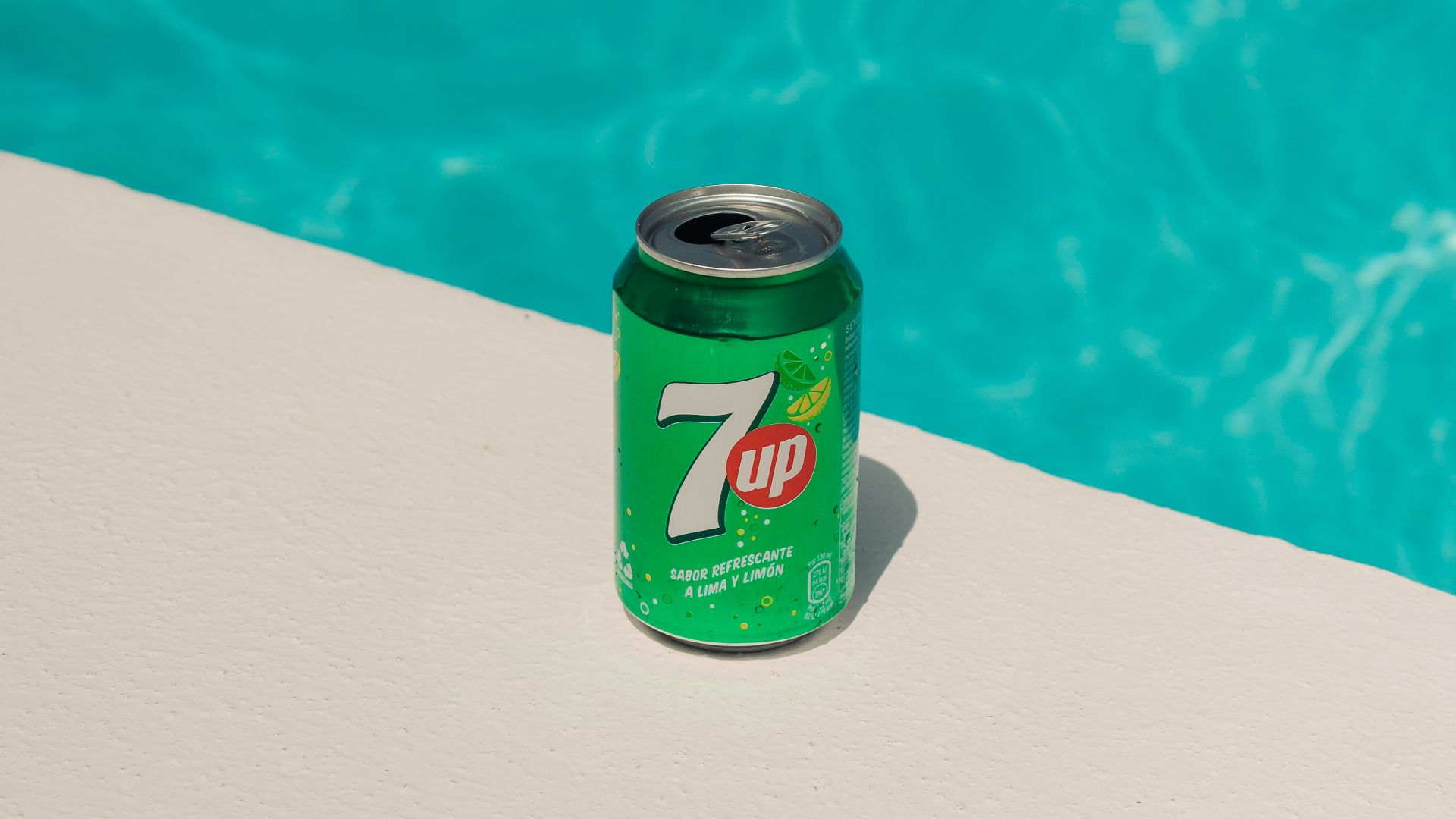 a can of 7up next to a swimming pool