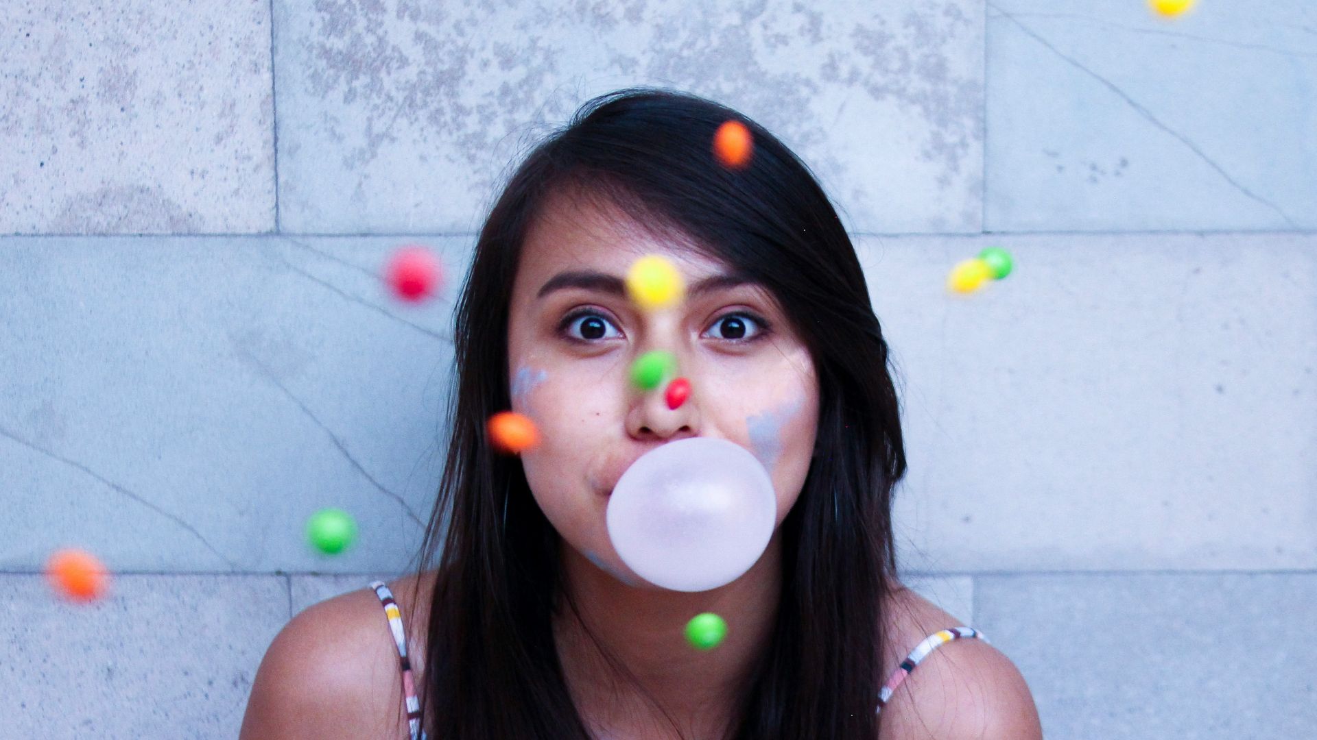 time lapse photo of woman making gum bubble