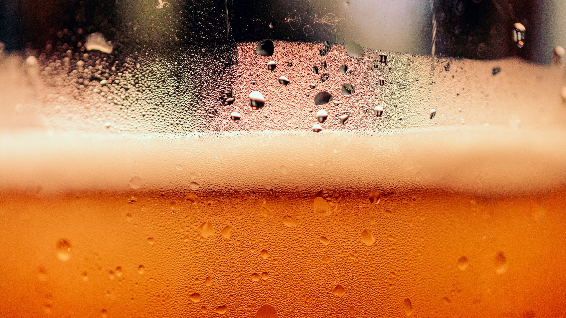 a close up of a glass of beer with drops of water