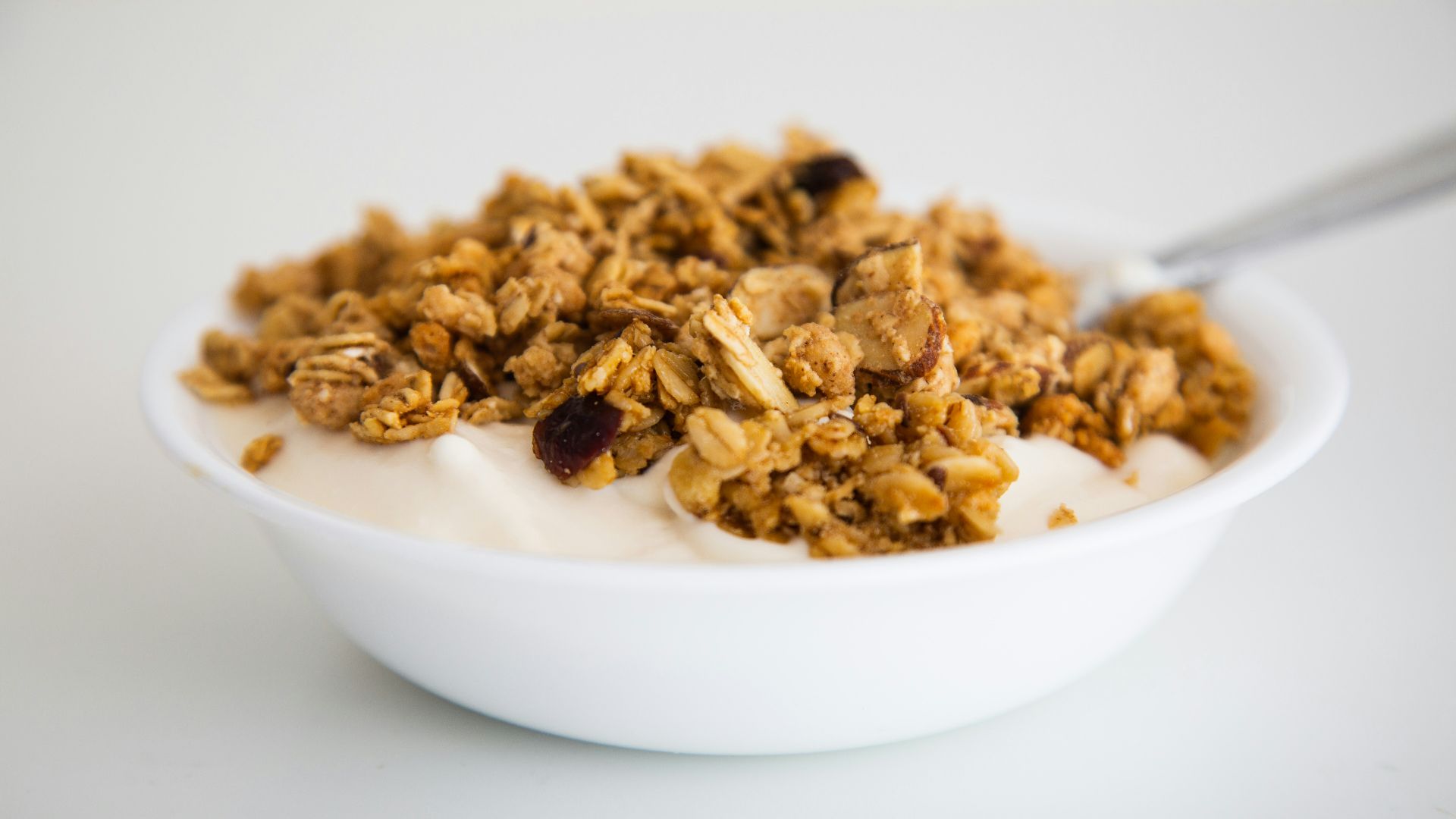 a bowl of granola and yogurt with a spoon