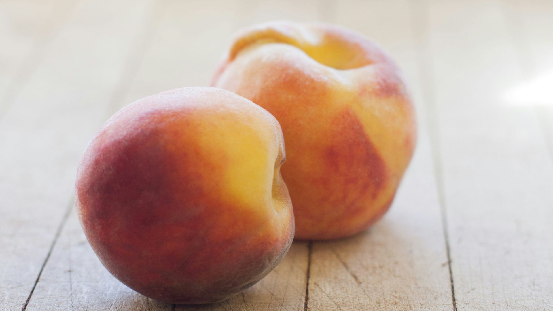 a couple of peaches sitting on top of a wooden floor