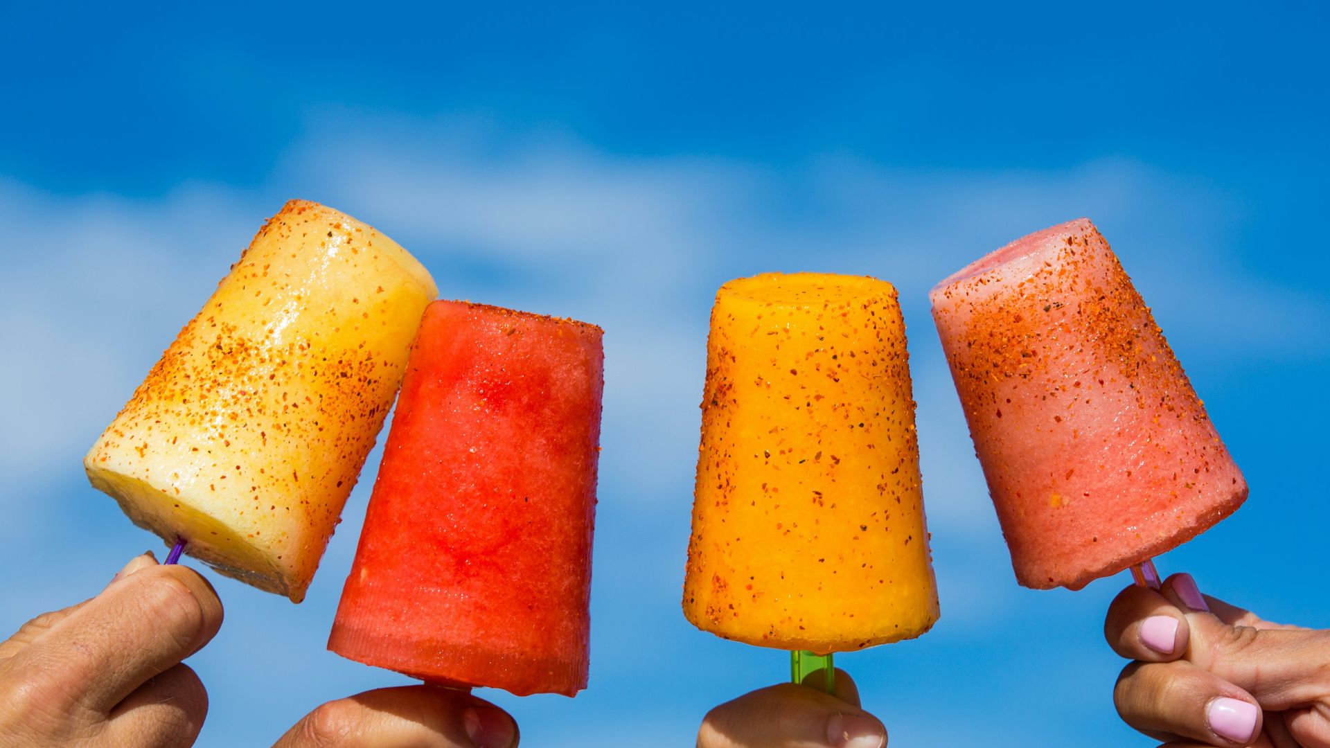 person holding orange ice pop