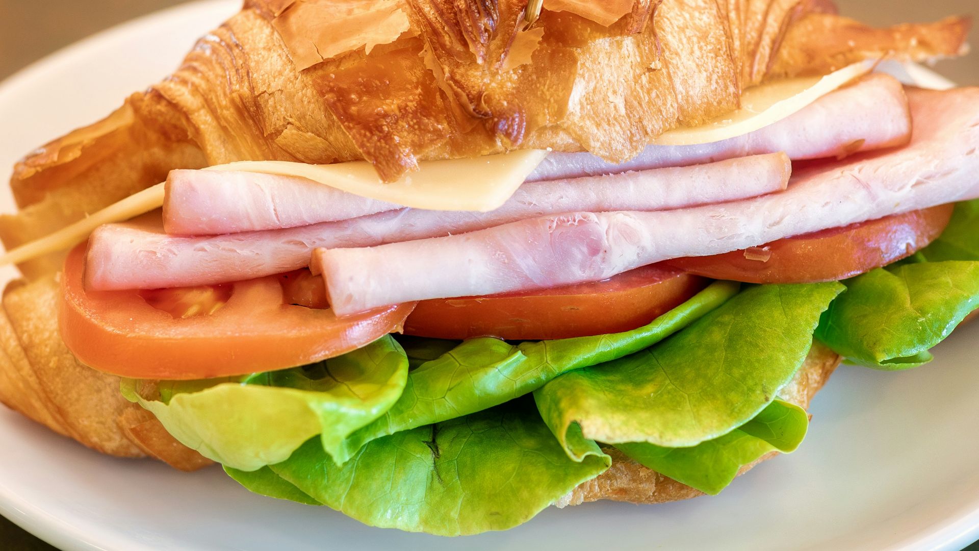 a white plate topped with a sandwich on top of a table