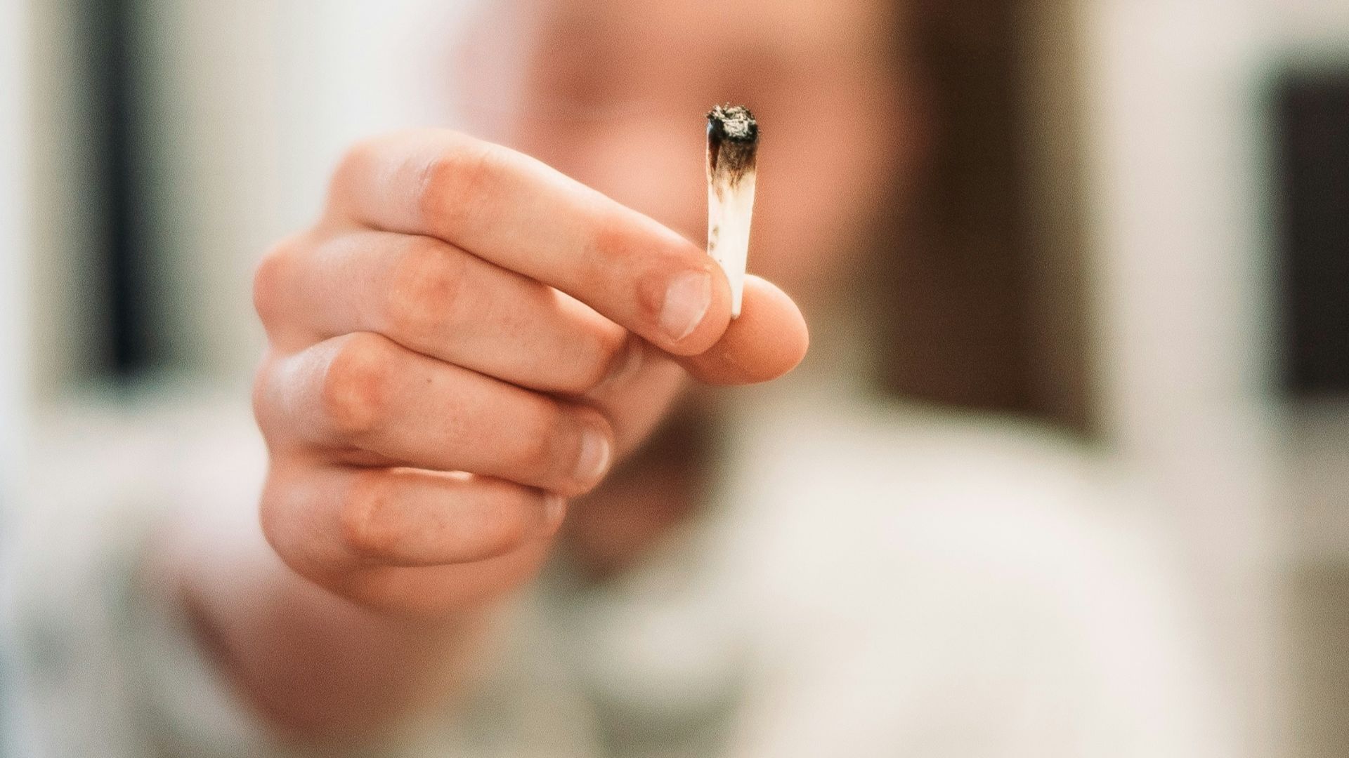 woman holding cigarette butt