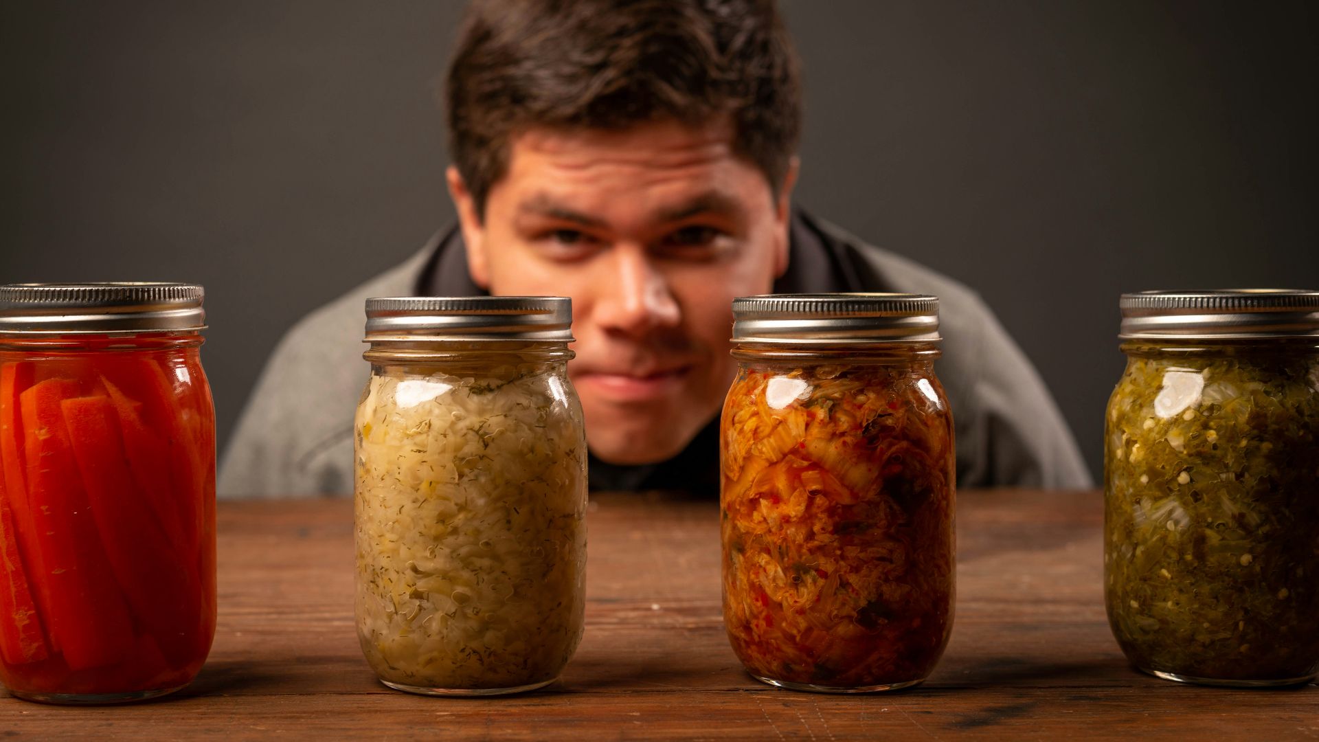 man in black shirt sitting beside brown wooden table