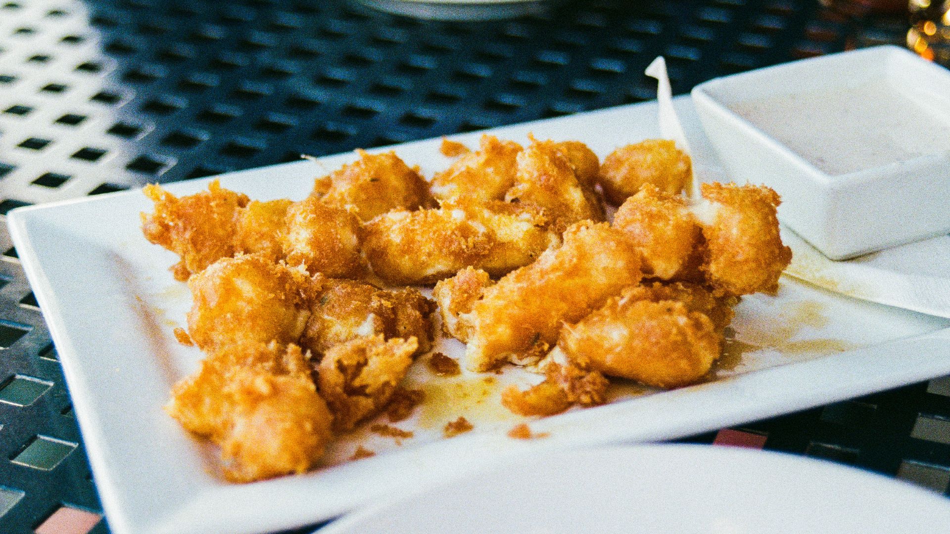 Fried cheese curds with dipping sauce are served.