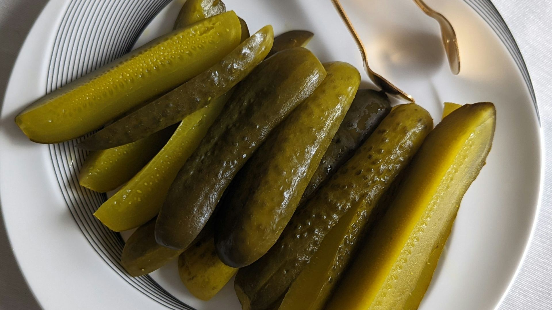 a white plate topped with pickles next to a fork