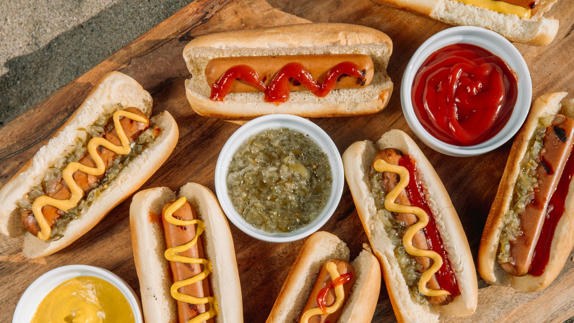 hotdog sandwich with sauce on brown wooden tray