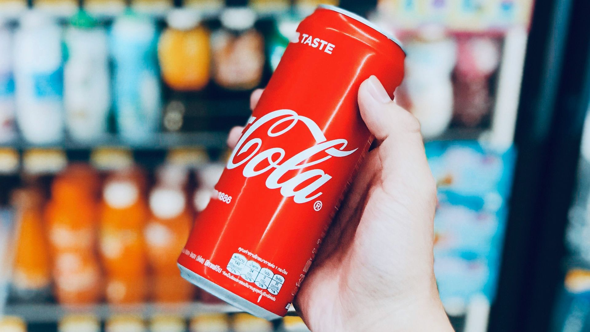 person holds Coca-Cola can