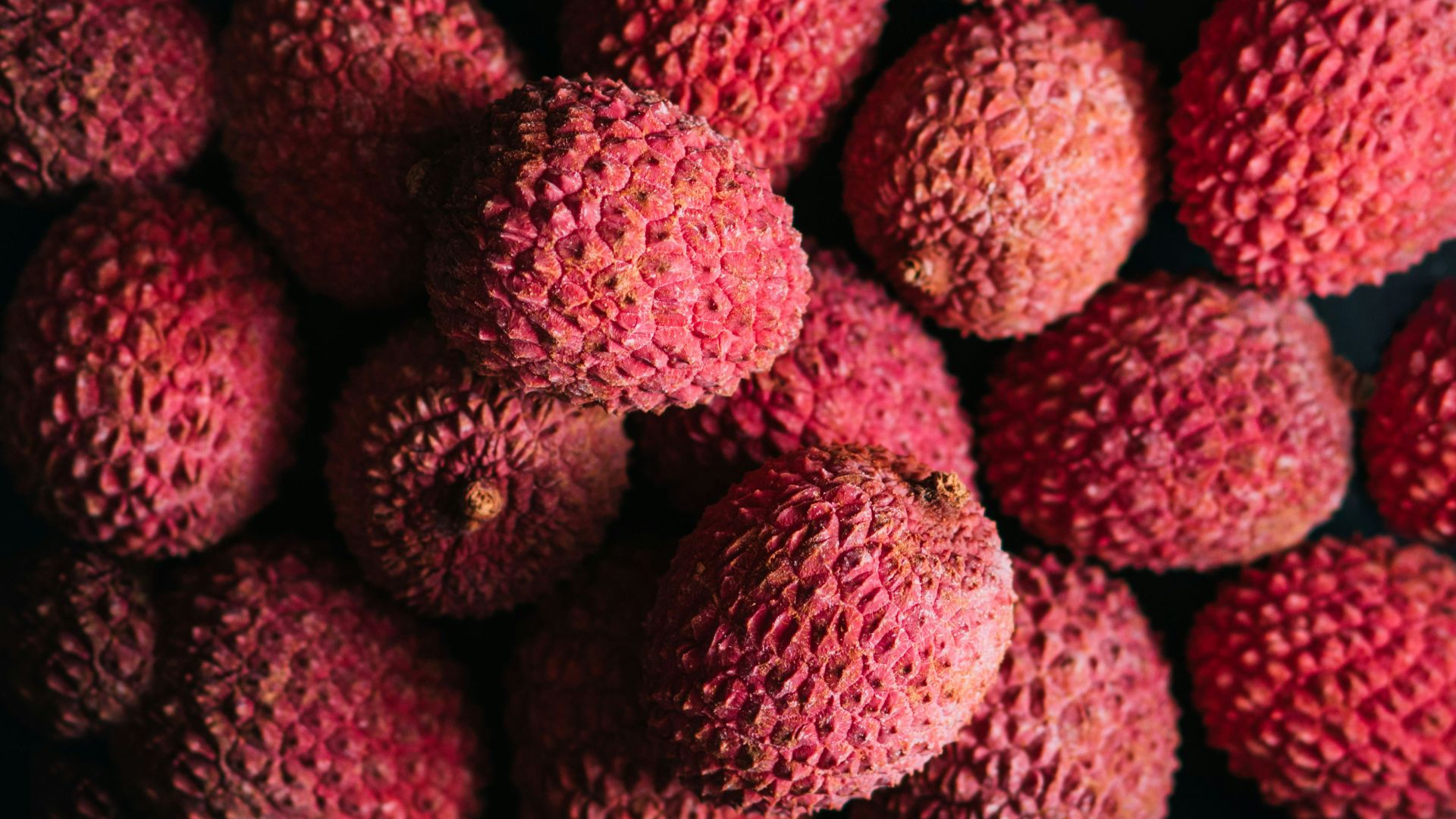 a pile of red fruit sitting on top of a table