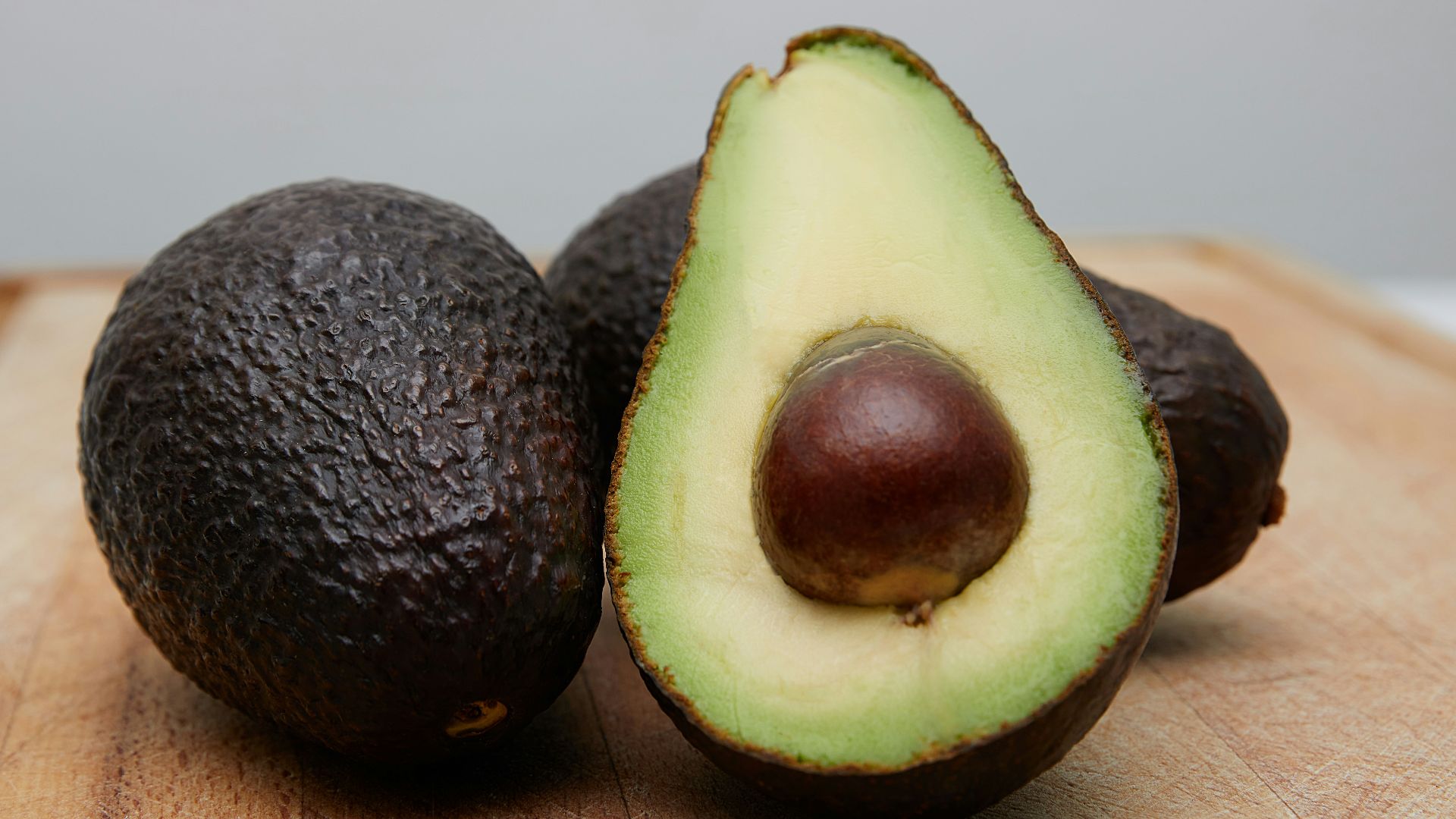sliced avocado fruit on brown wooden table