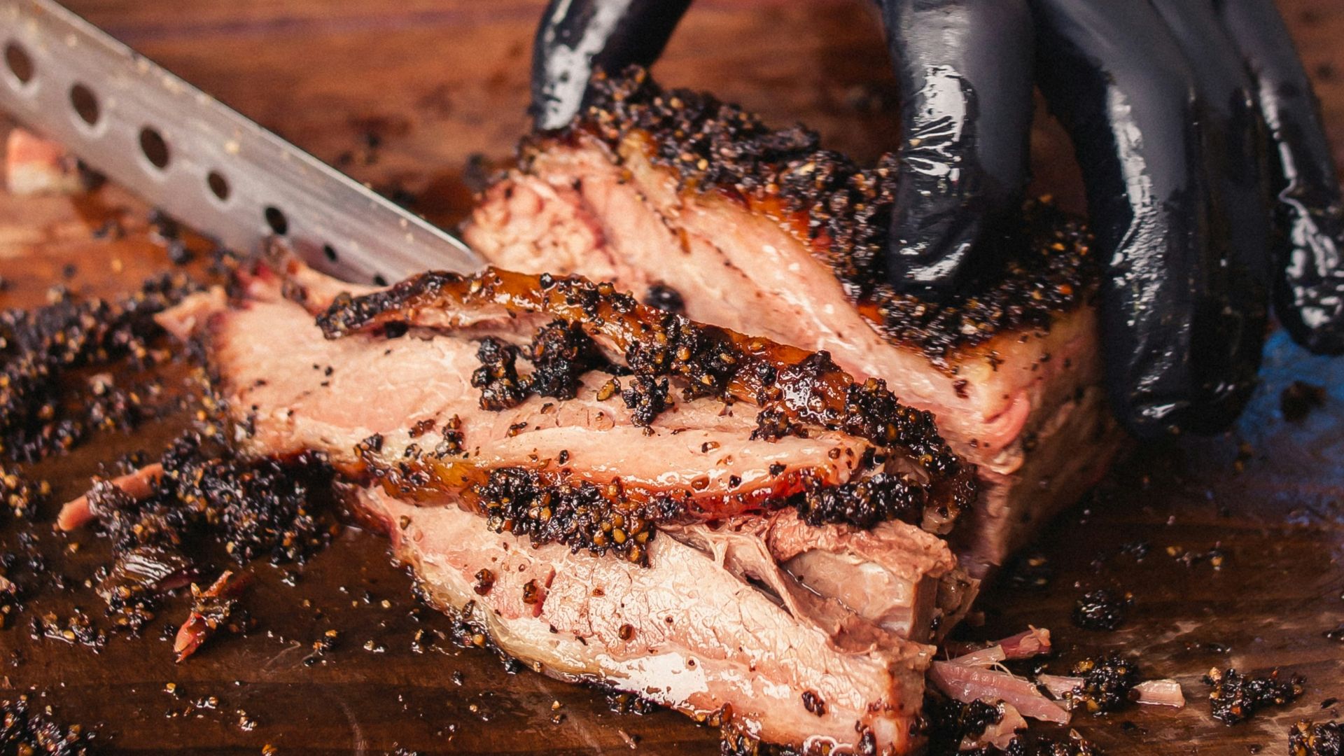 a person cutting a piece of meat with a knife