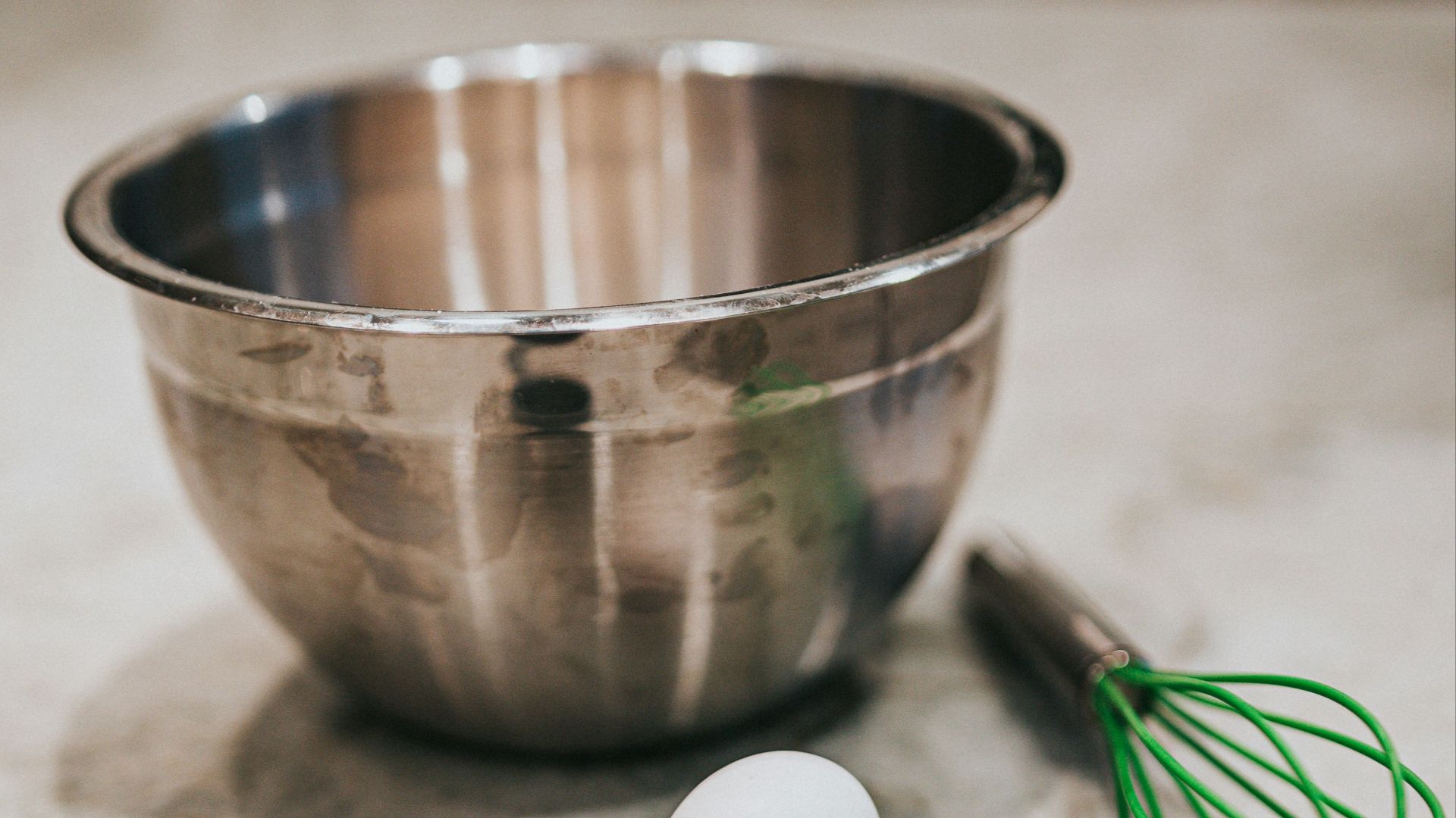 white egg beside stainless steel bowl