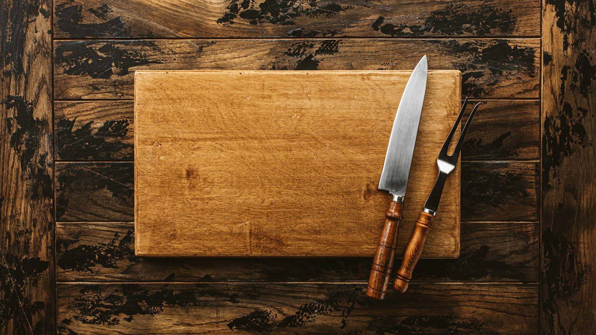 a knife and a board on a wooden surface