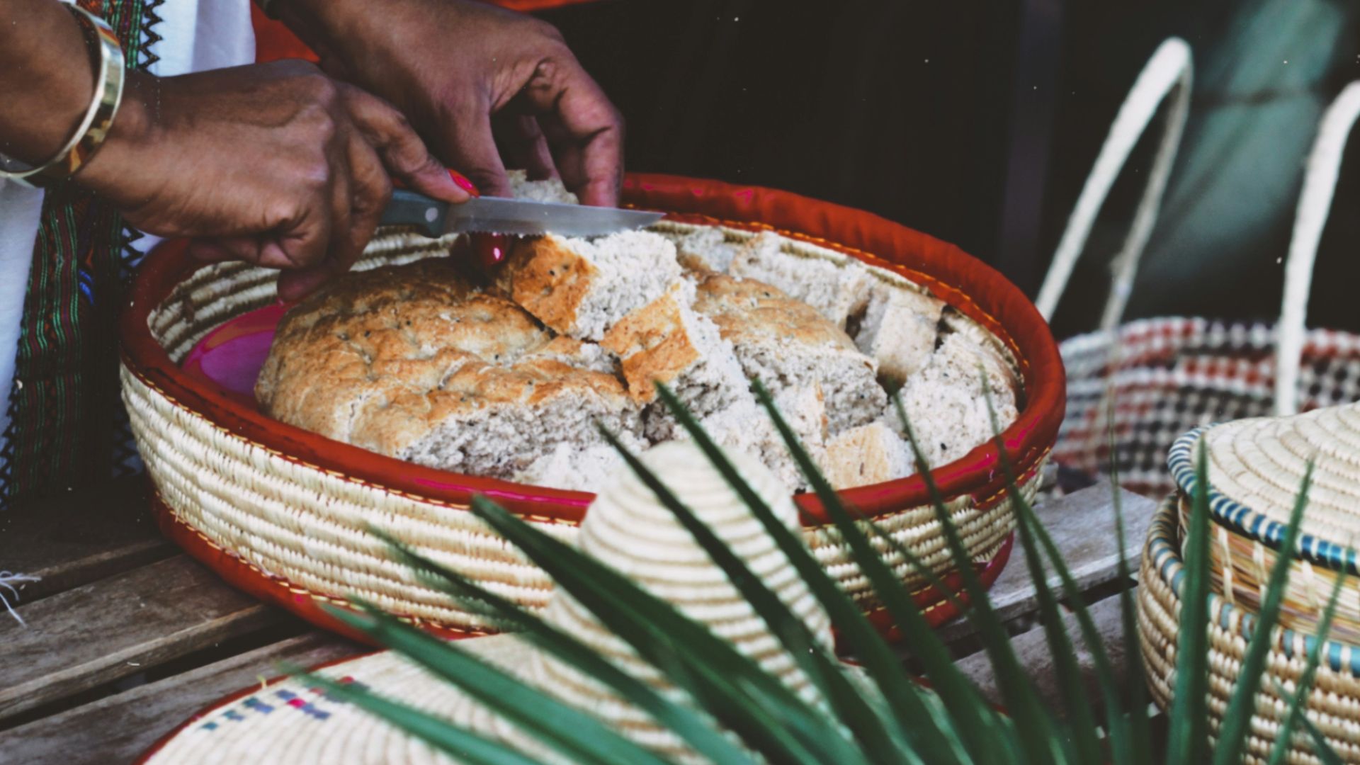 person in white shirt sitting on chair in front of table with food