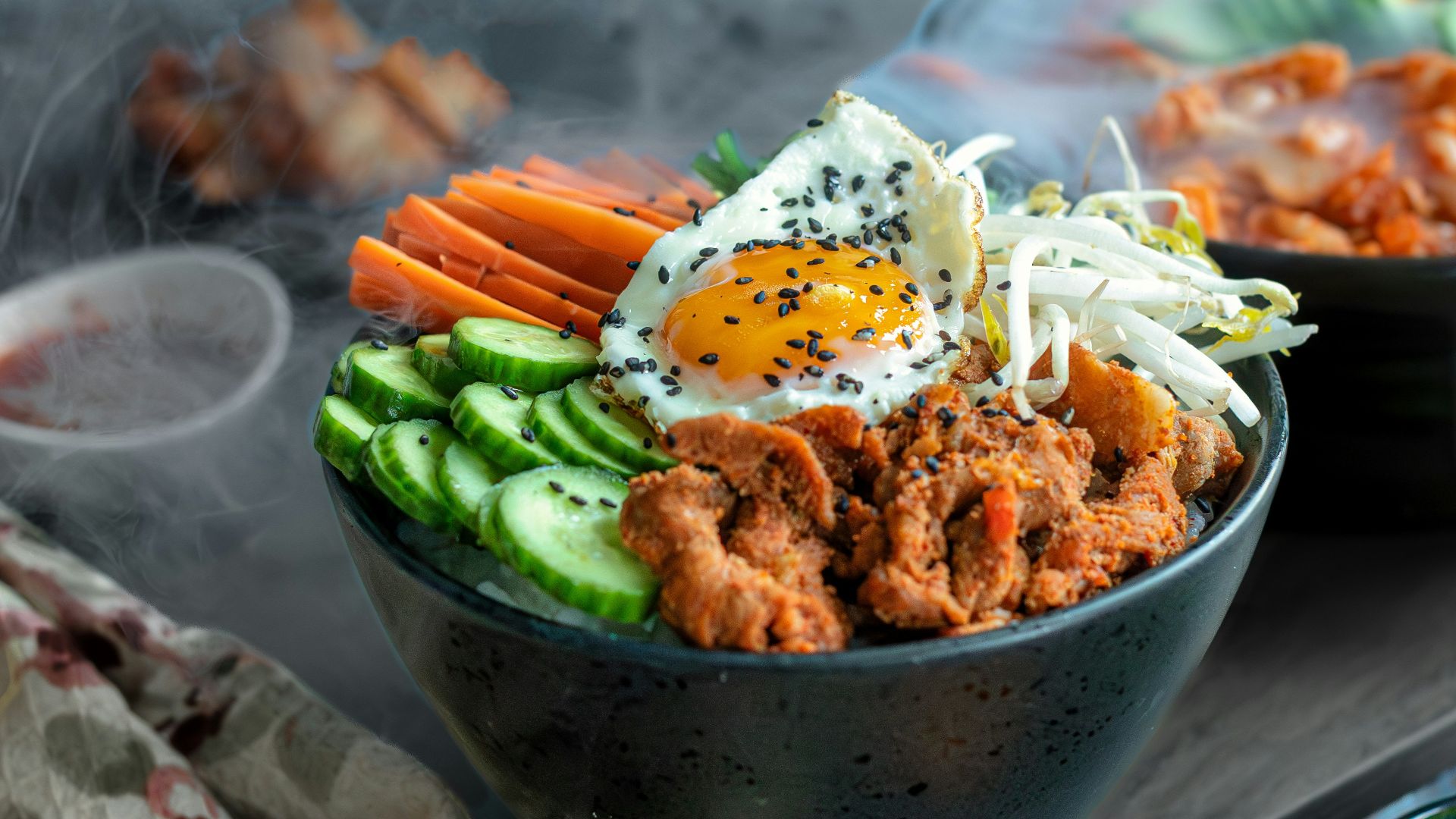 A table topped with bowls of food and chopsticks