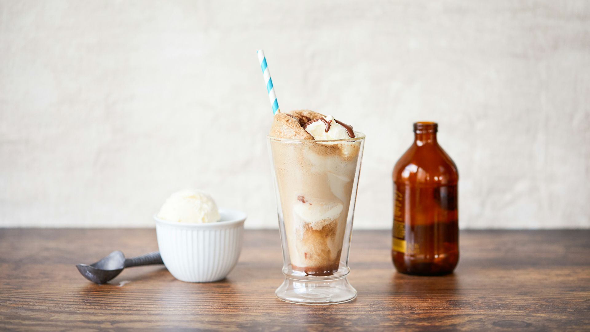 a glass of ice cream next to a bottle of beer