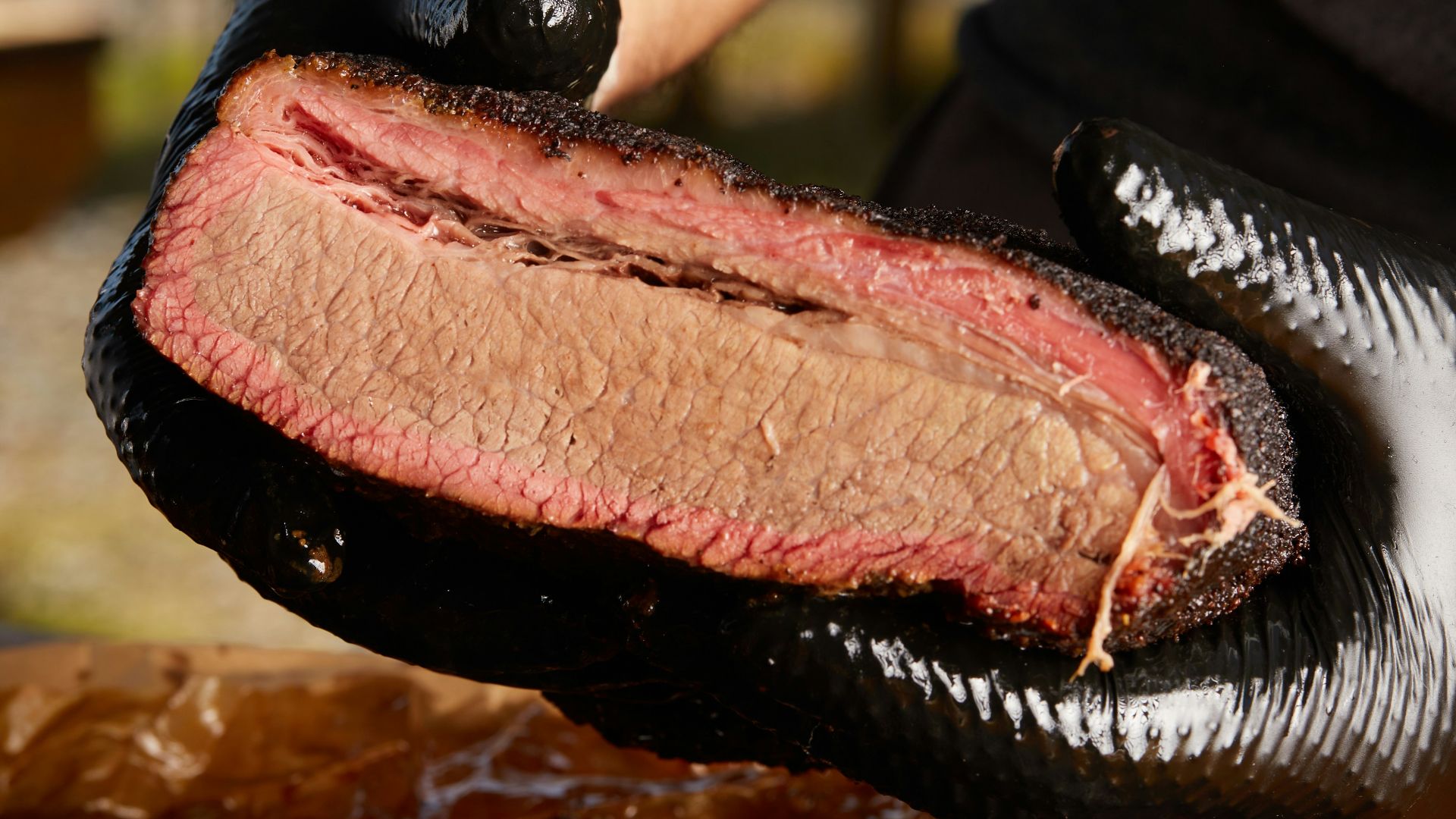 person holding raw meat during daytime