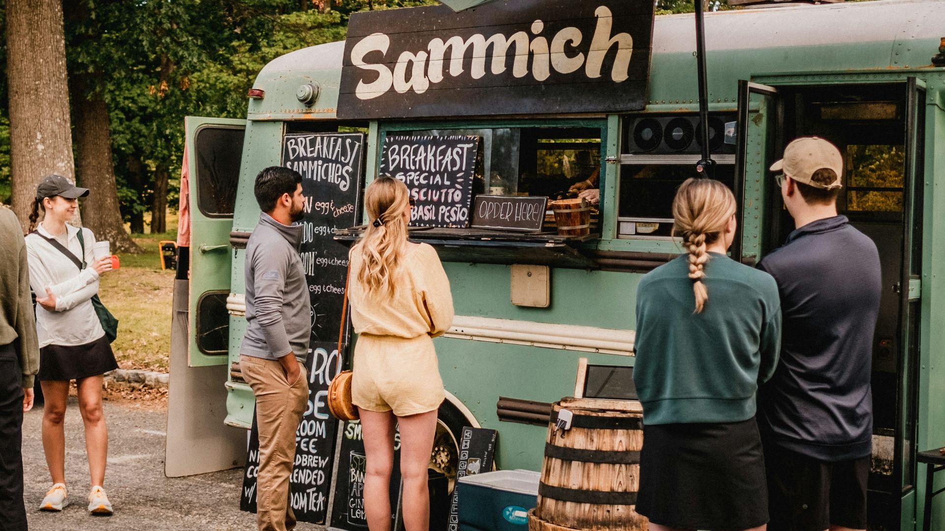 a group of people standing outside of a food truck