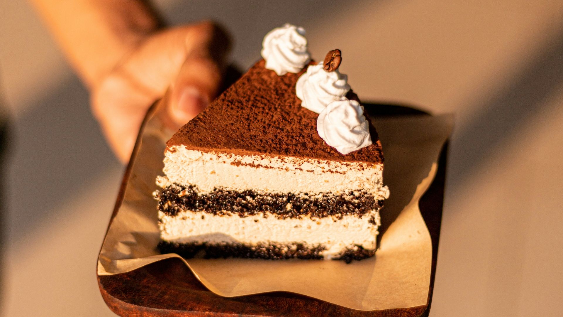 a person holding a piece of cake on a plate