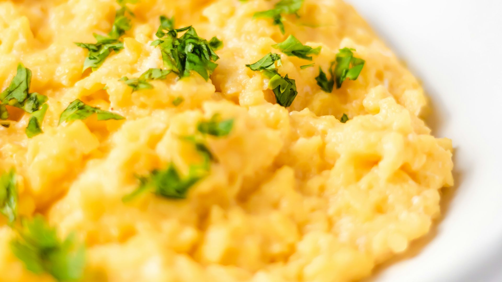 a bowl of mashed potatoes with parsley on top