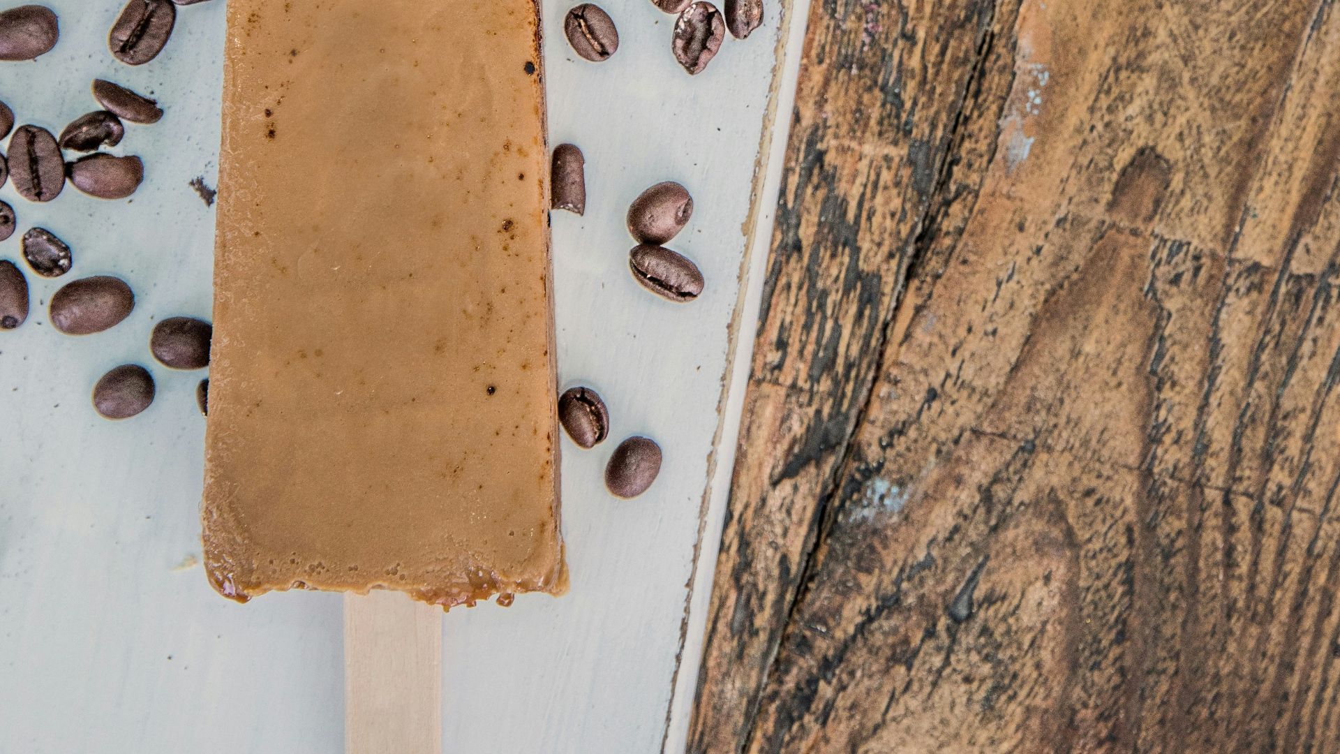 A popsicle with coffee beans on top of it