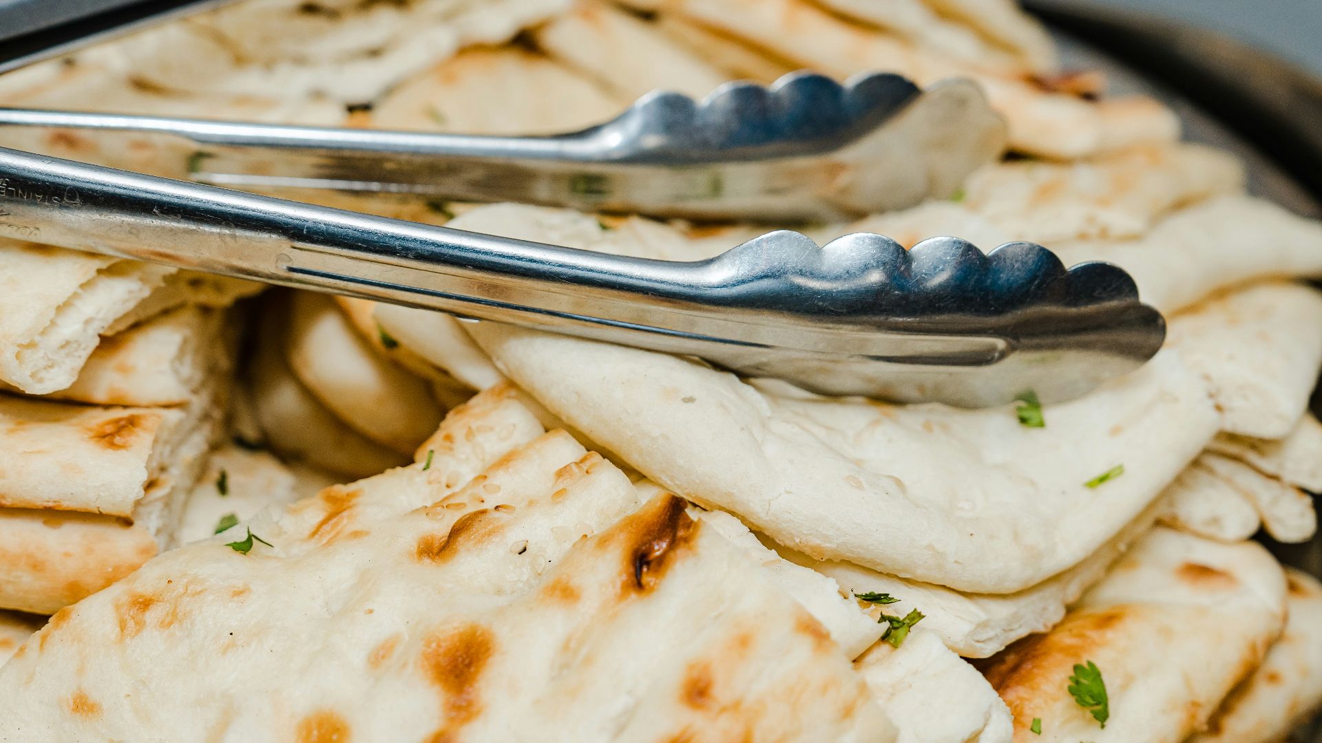 a bowl filled with pita bread and a fork