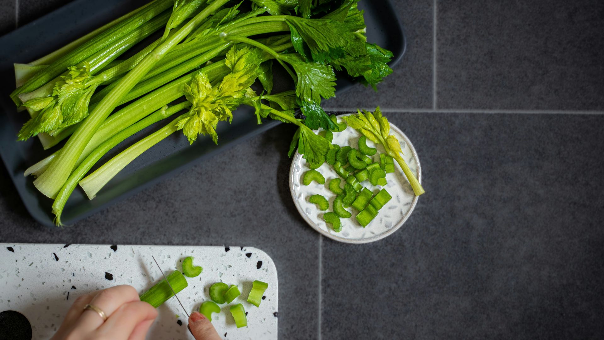 a person chopping celery on a cutting board