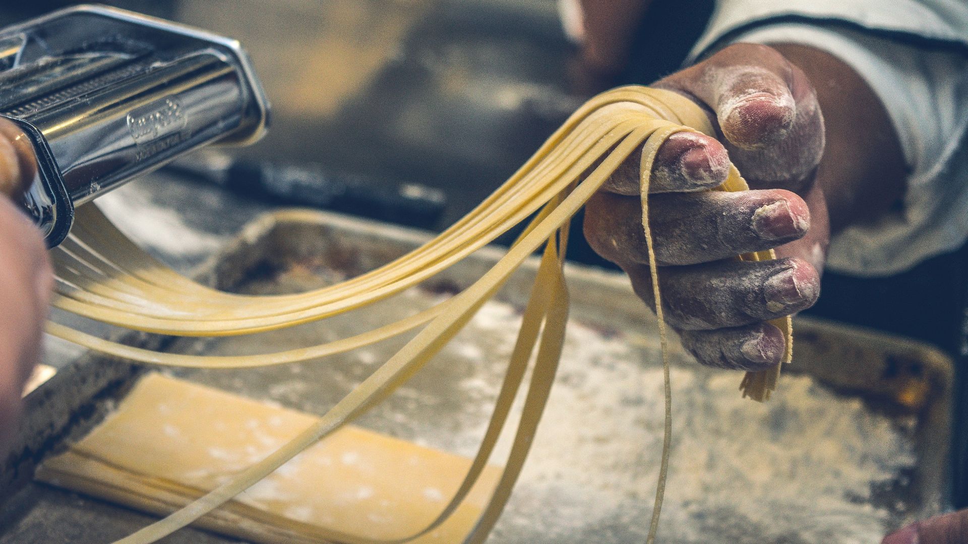 person sheeting dough