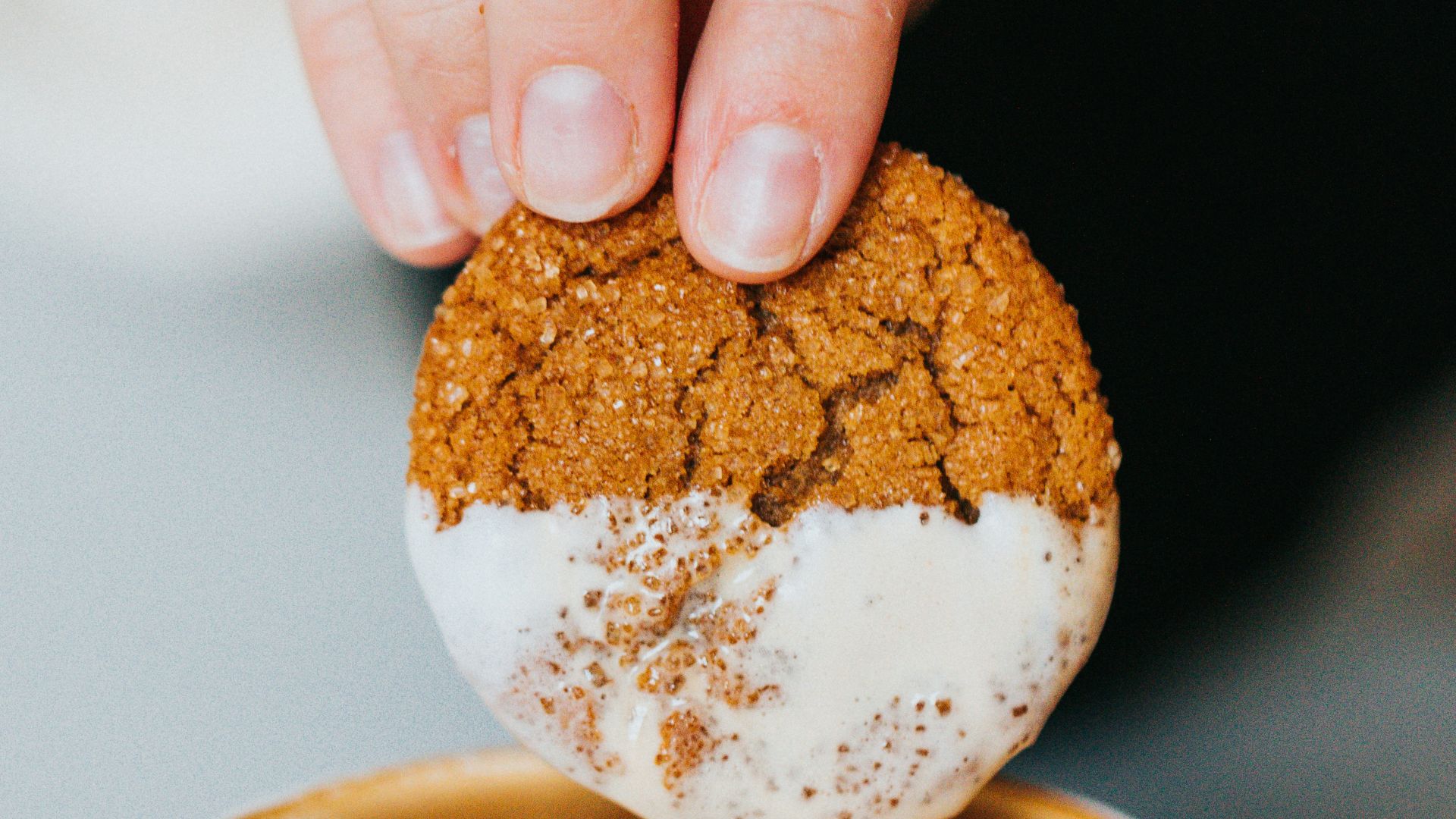 person holding white ceramic mug with brown and white liquid