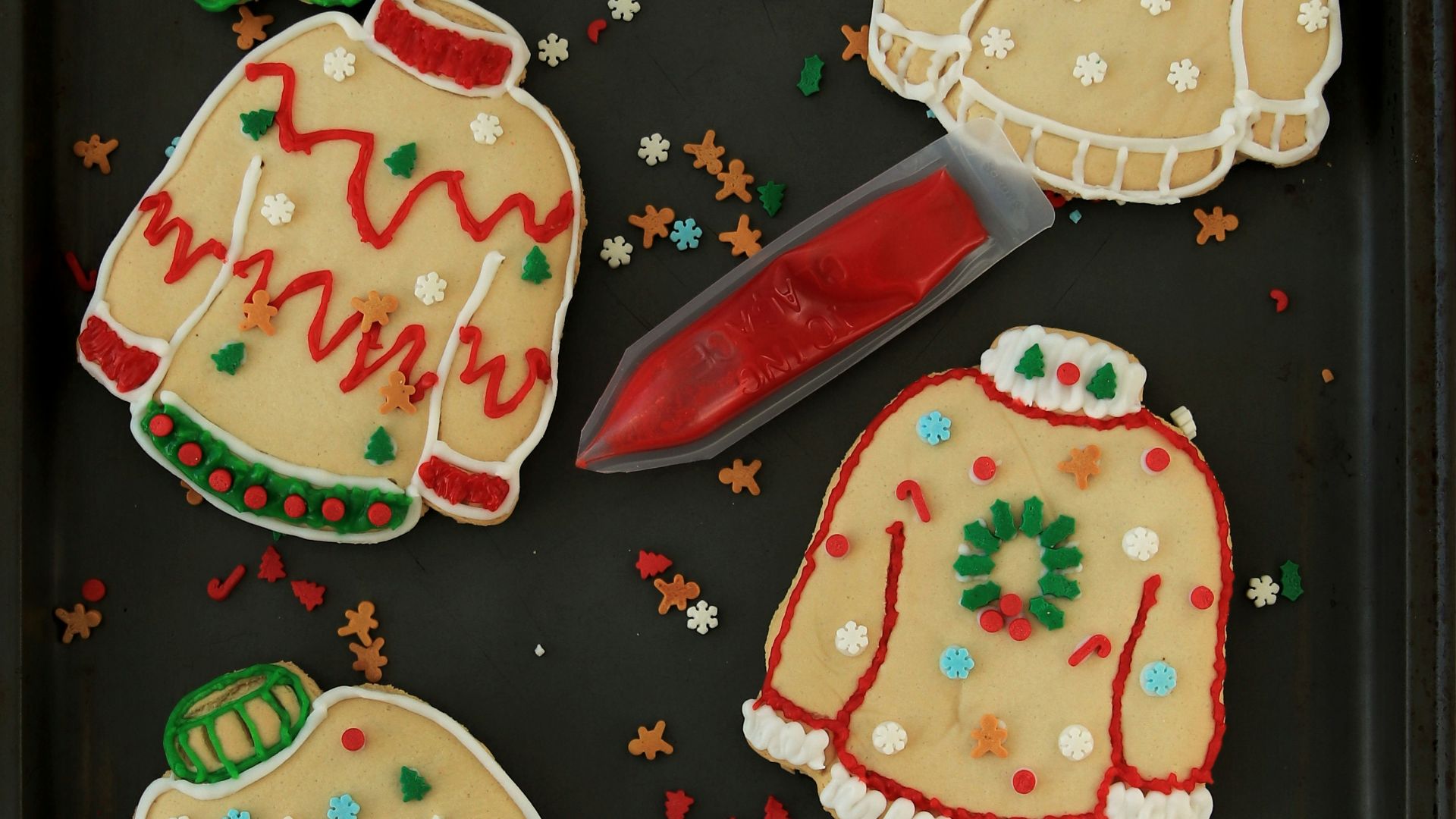 a tray of decorated christmas sweaters and mittens