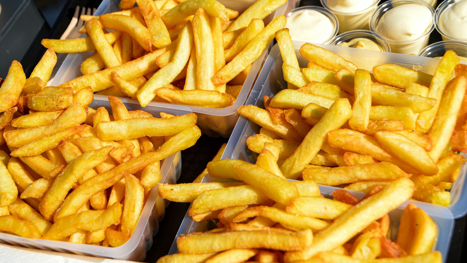 several trays of french fries sitting on a table