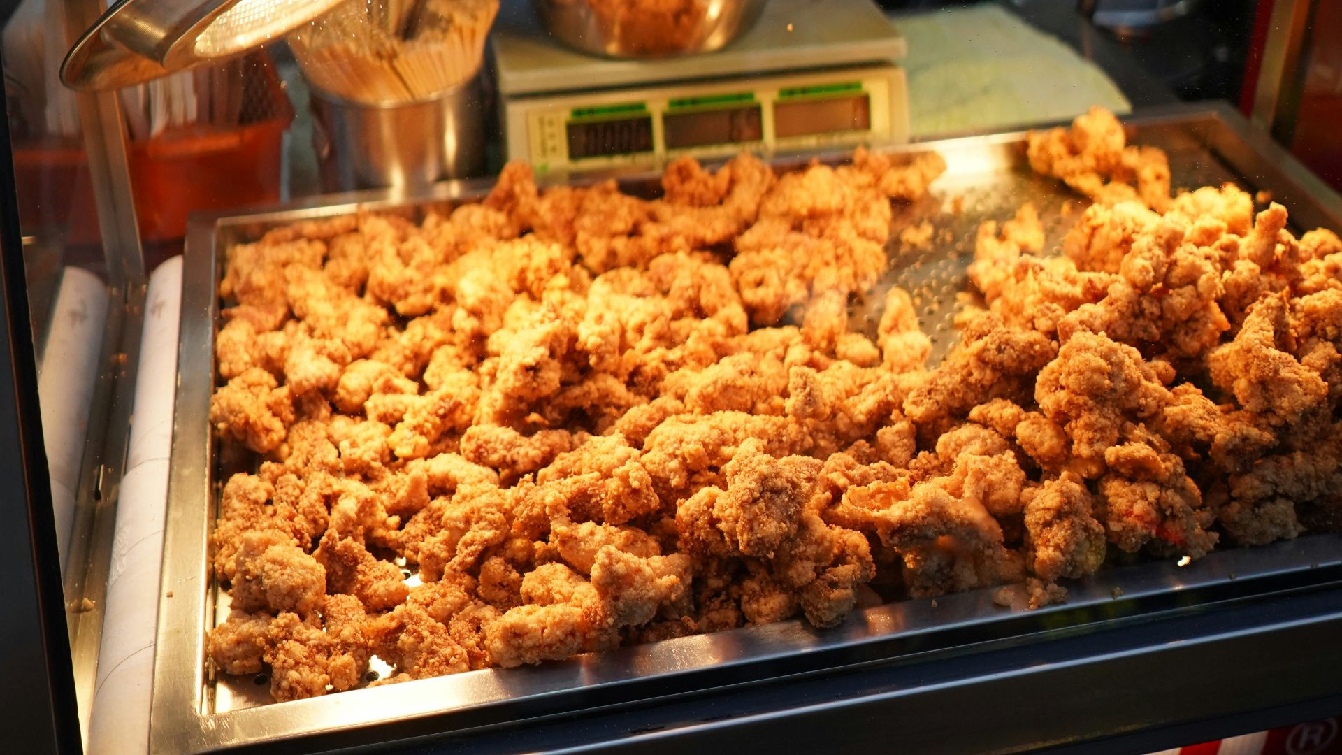 Freshly fried chicken is being served at a food stall.