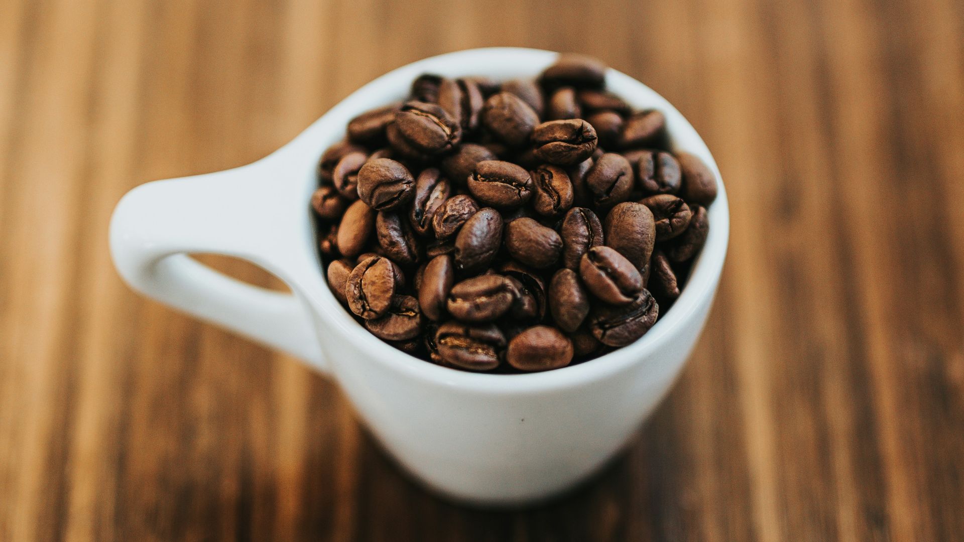 round white ceramic mug with coffee beans