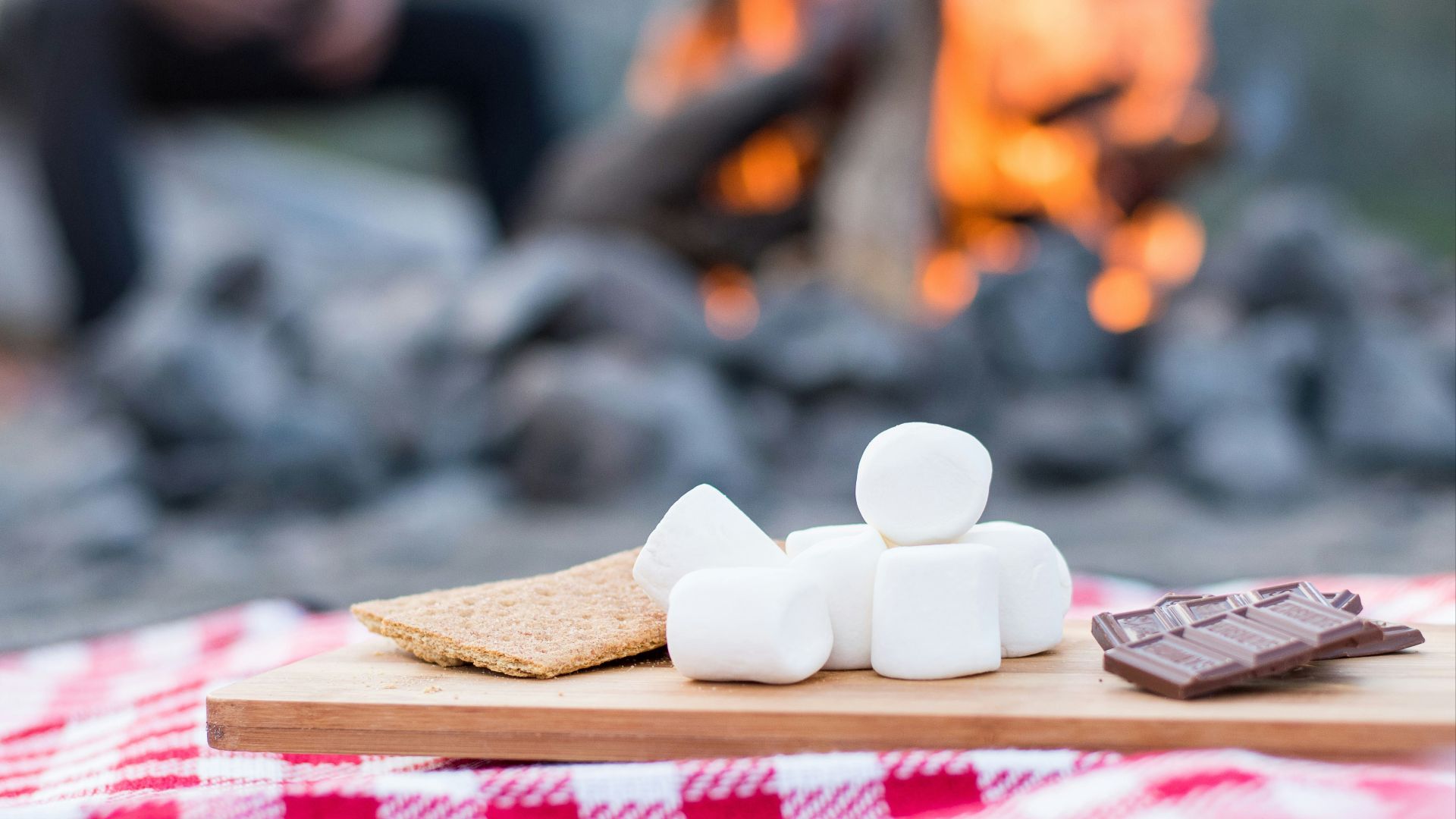 marshmallows and chocolate bar on brown wooden board